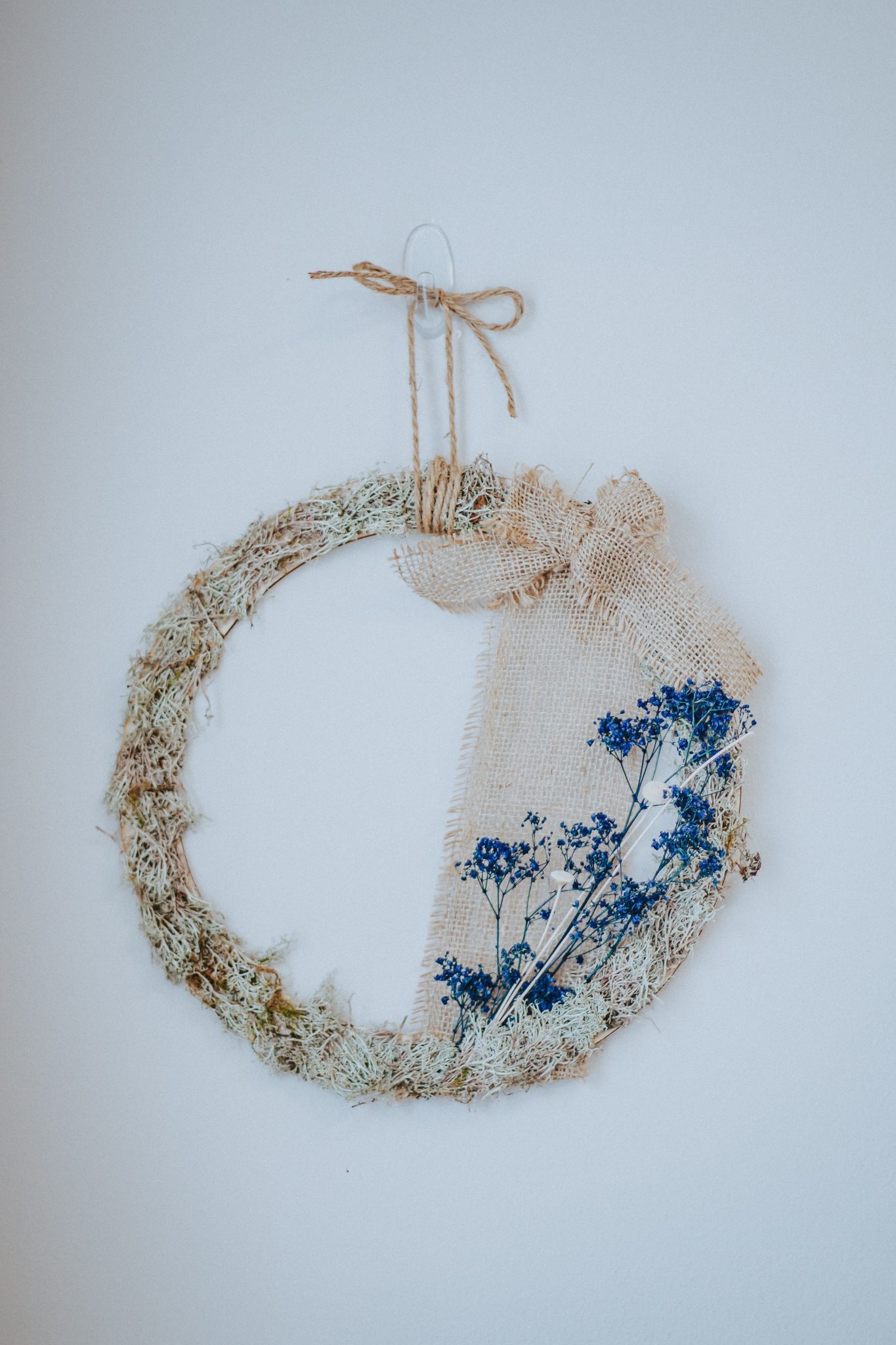 A charming boho-style wreath with dried flowers and burlap, perfect for home decoration.