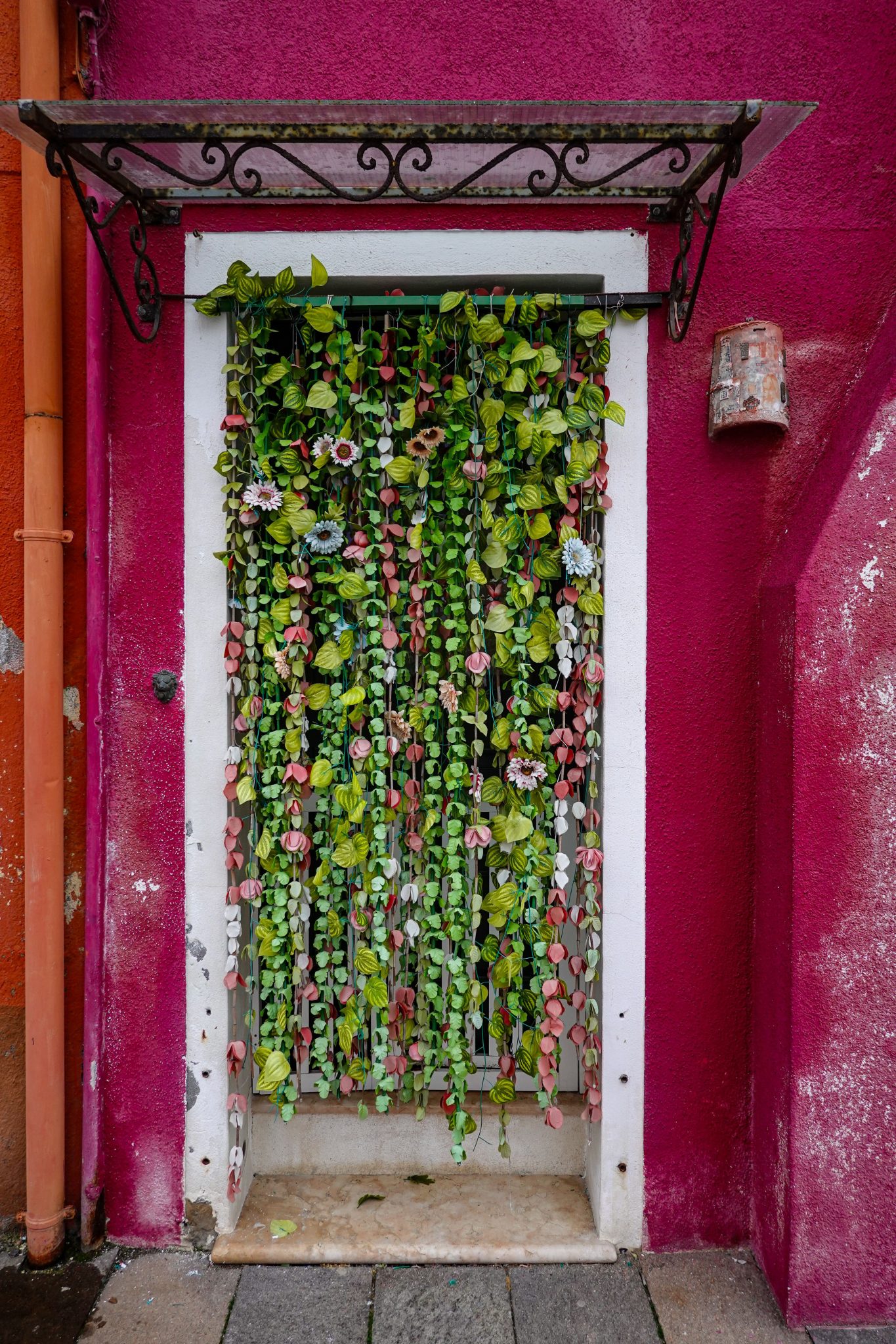 A colorful doorway adorned with lush hanging greenery