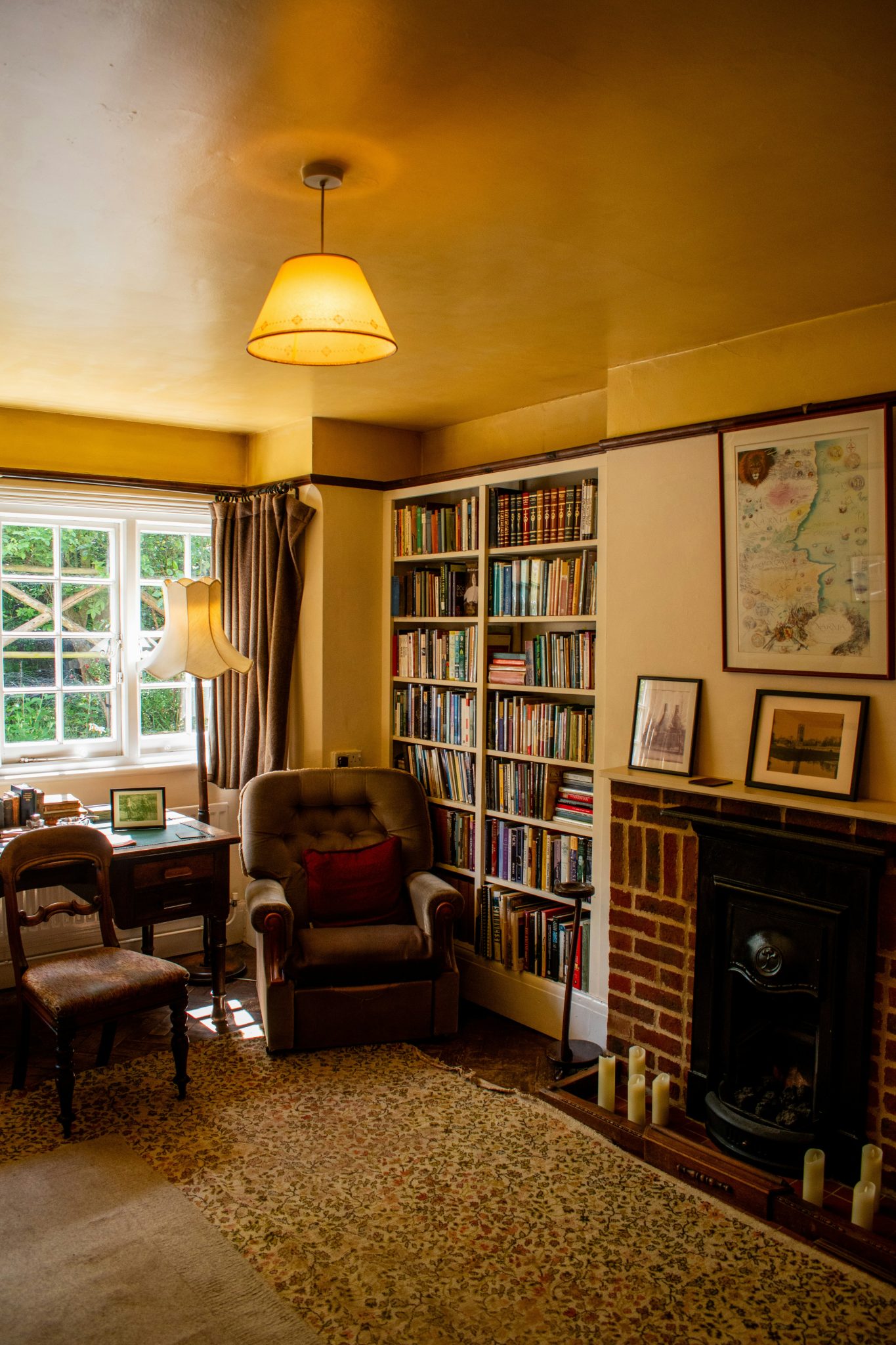A cozy living room with an armchair, bookshelf, and fireplace.