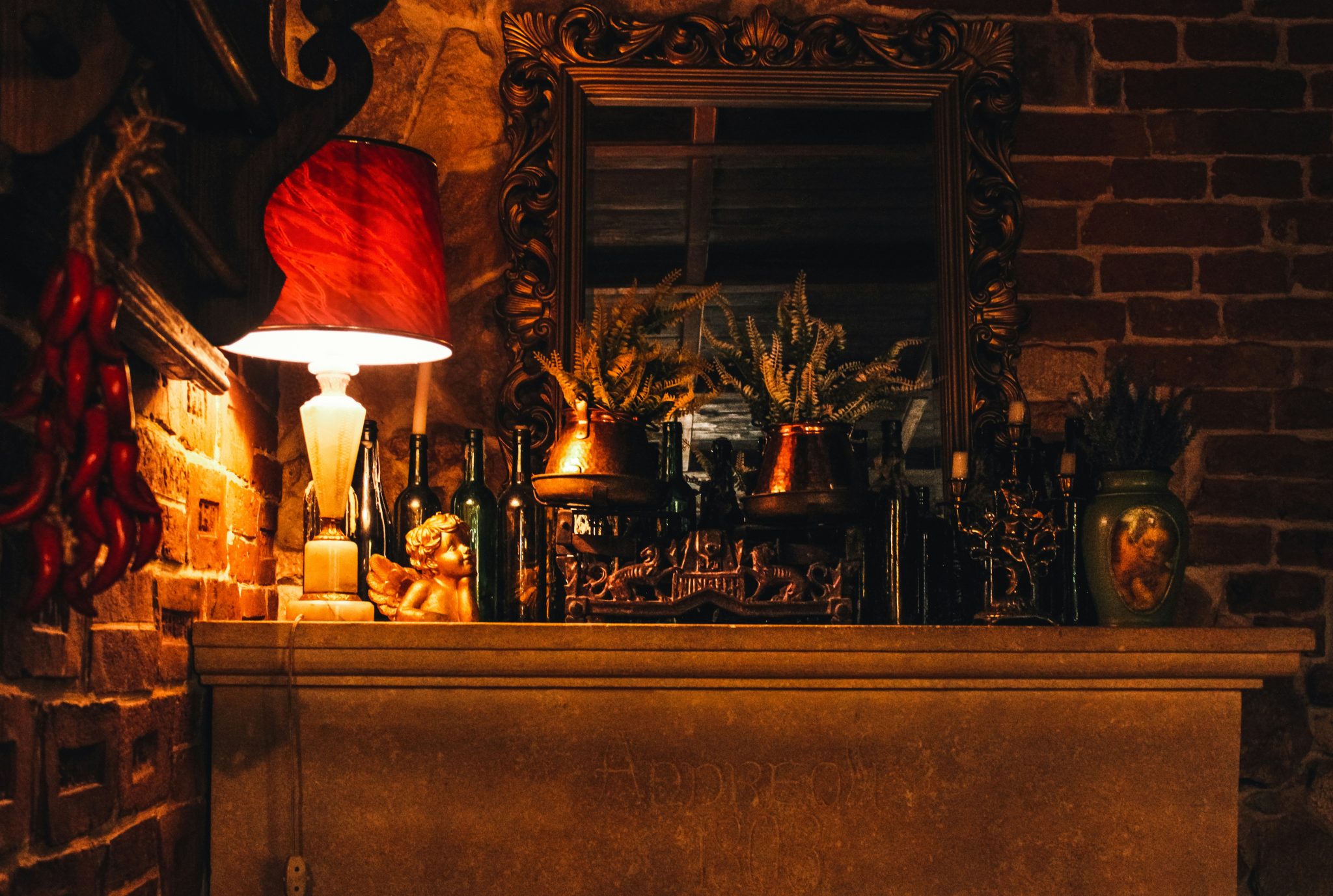 A dimly lit fireplace mantel with various objects