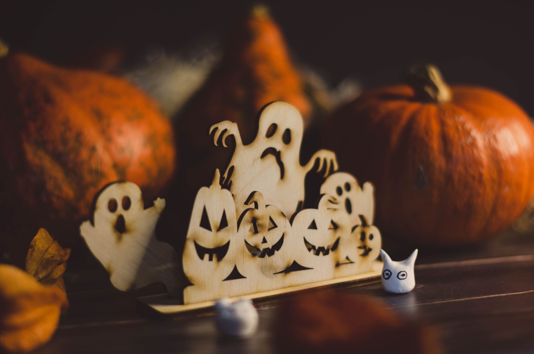 A festive Halloween-themed display with wooden ghosts and pumpkins.
