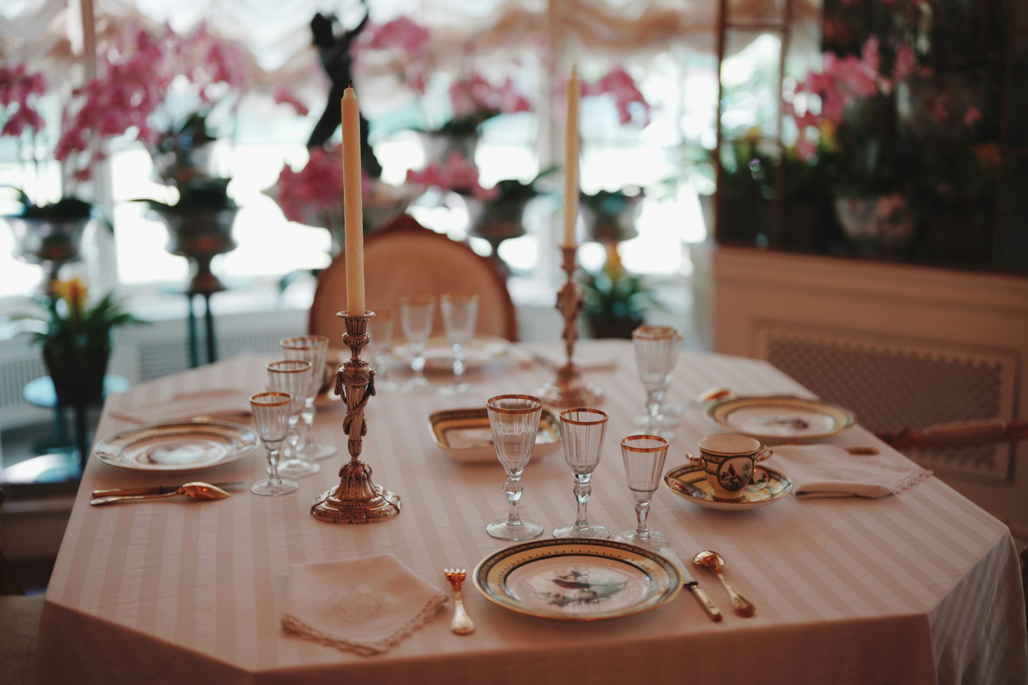 A formal dining table set with china and silverware