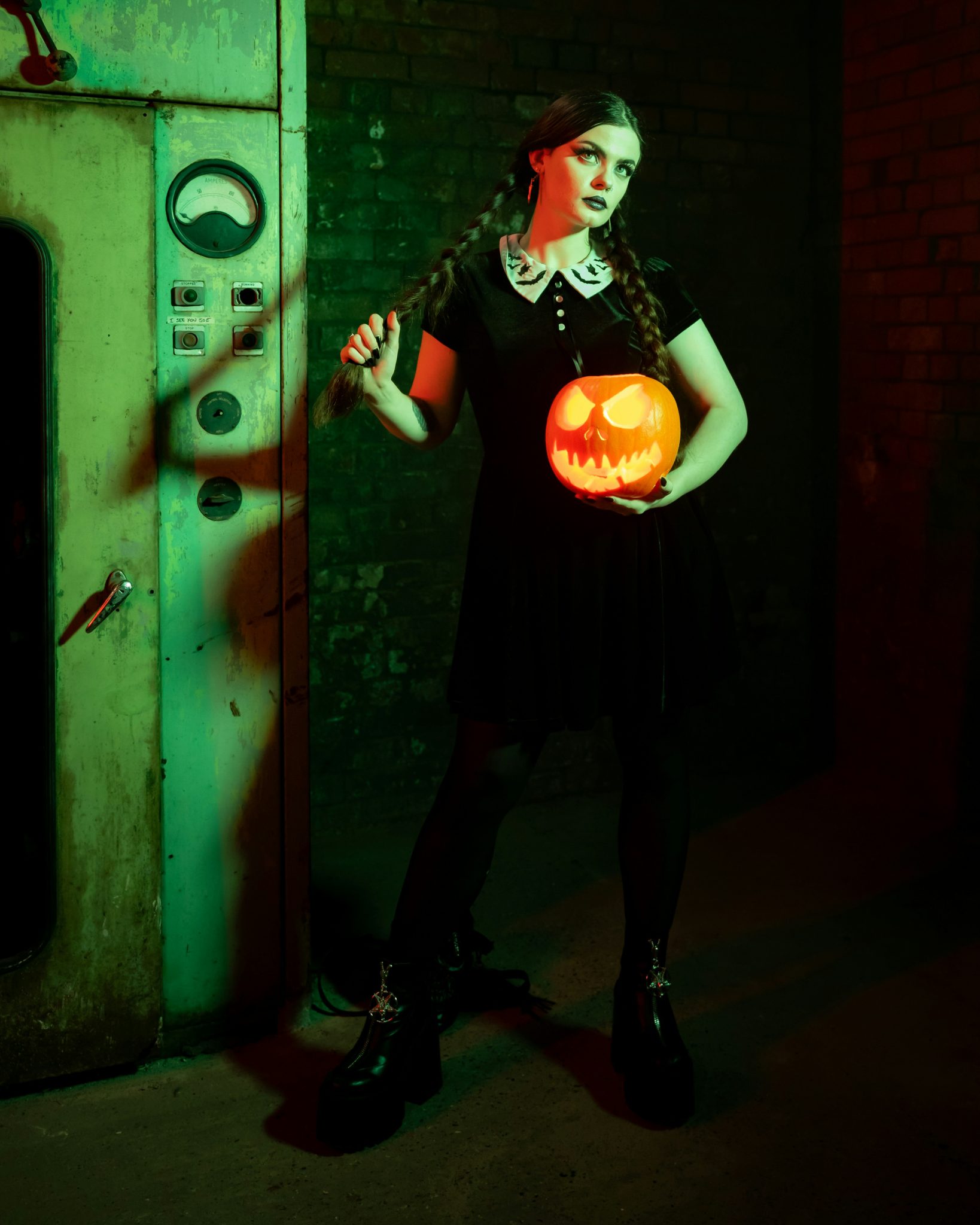 a person wearing a black dress and holding a pumpkin