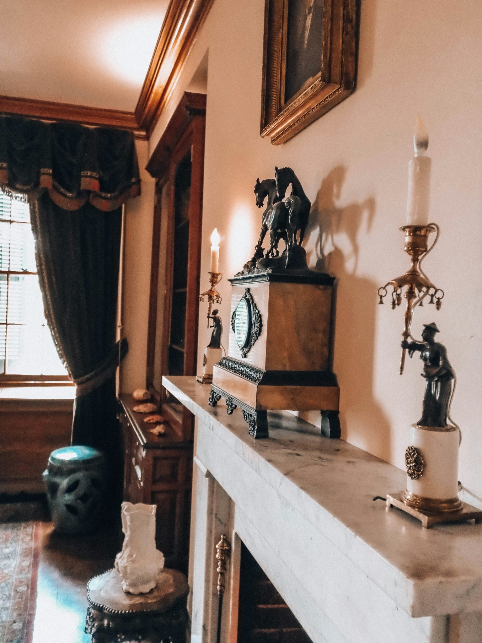 Antique mantelpiece with a clock, candlesticks, and elegant historical decor