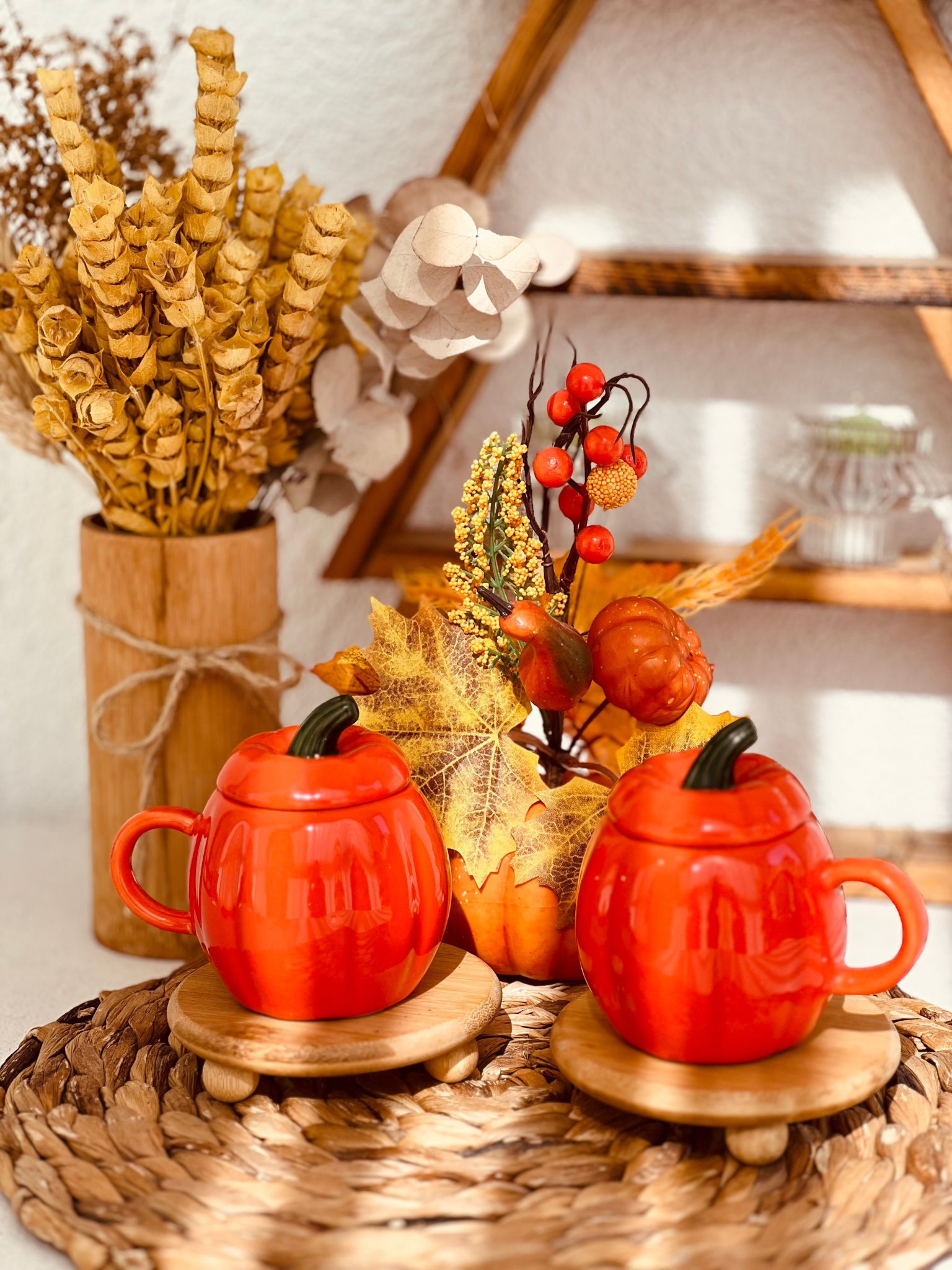 Autumn-themed decor with pumpkin mugs and dried flowers, perfect for fall settings.