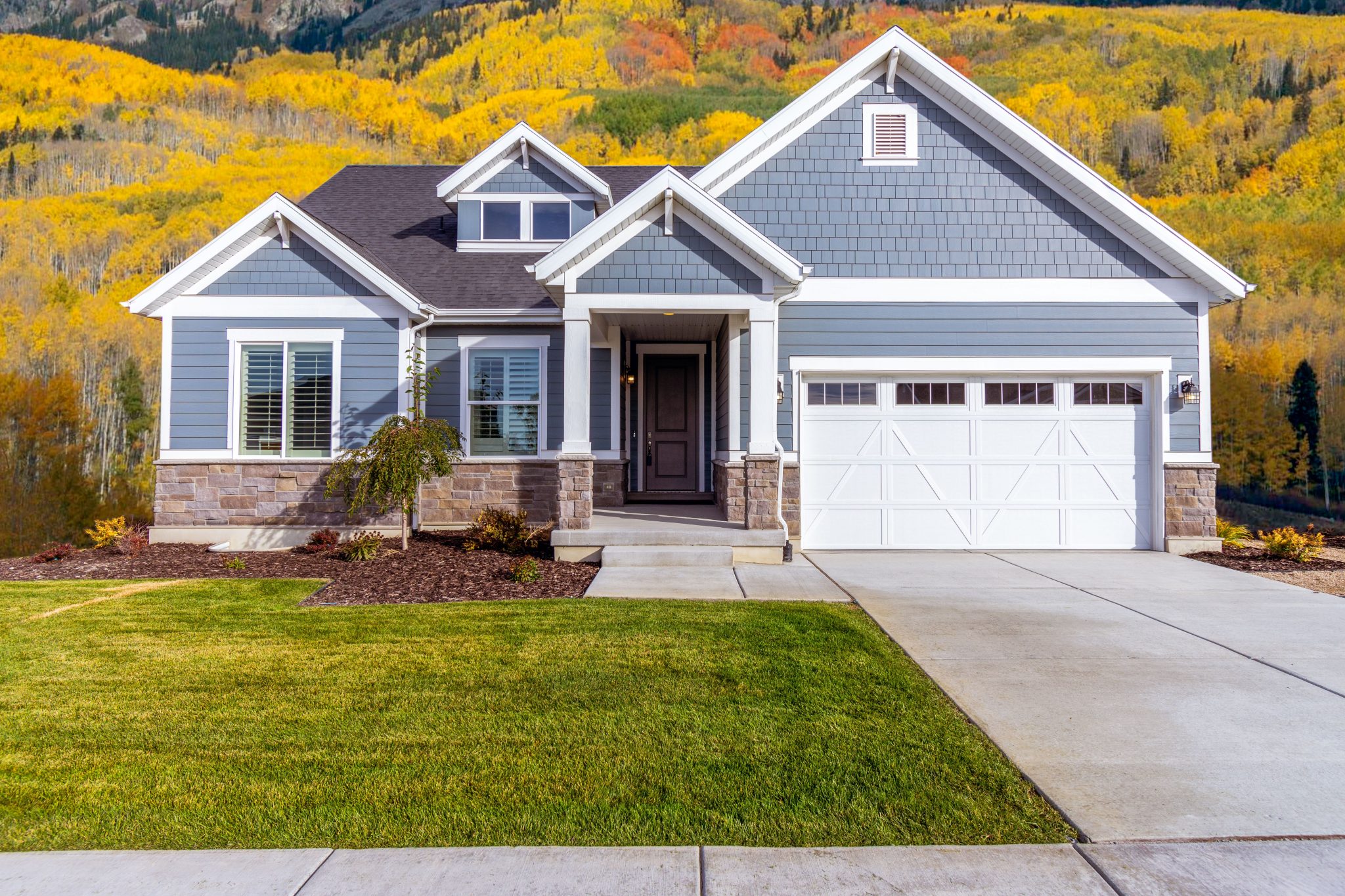 Beautiful suburban house with vibrant autumn foliage backdrop.