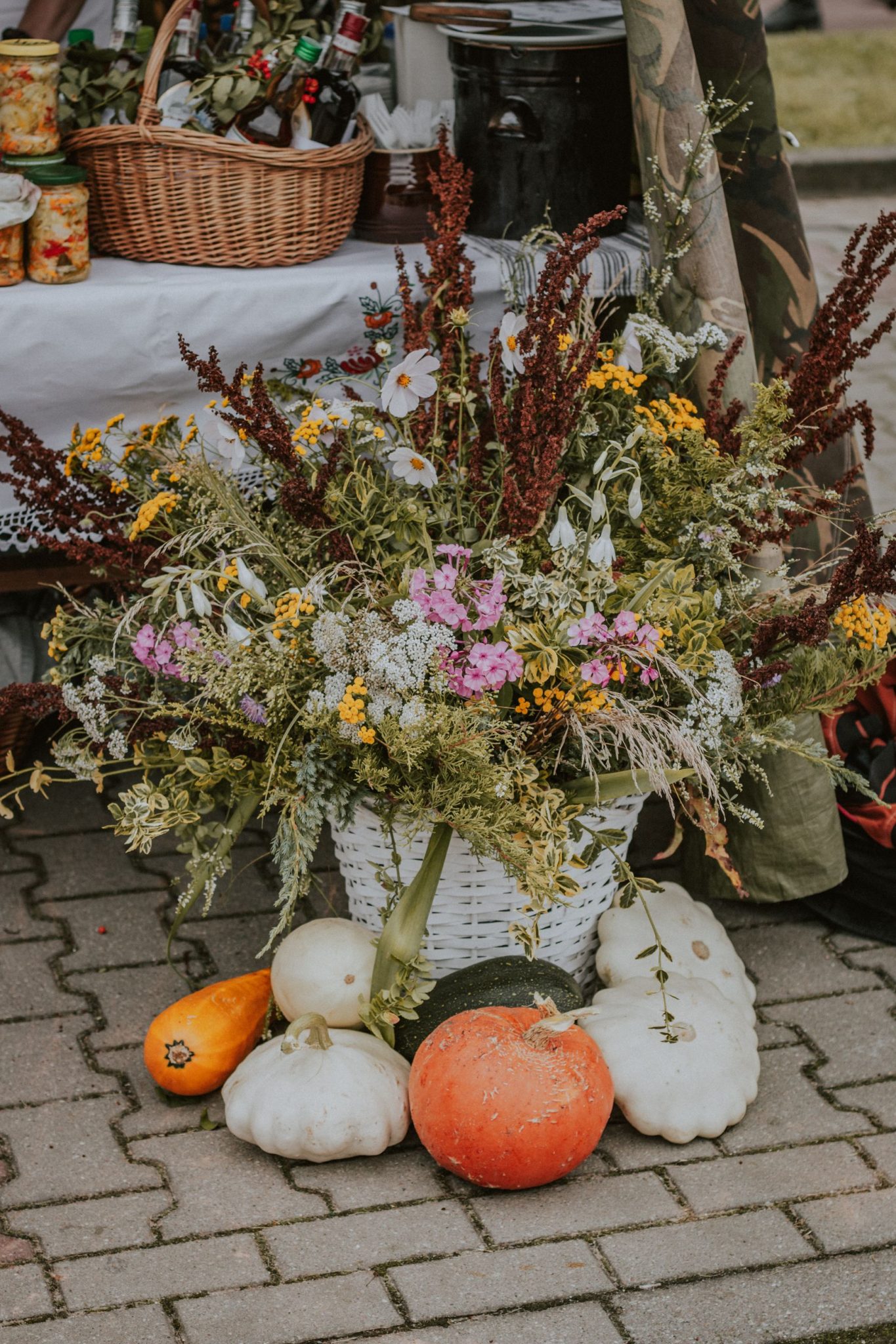 Charming autumn arrangement featuring diverse flowers and pumpkins, perfect for a rustic decor ambiance.