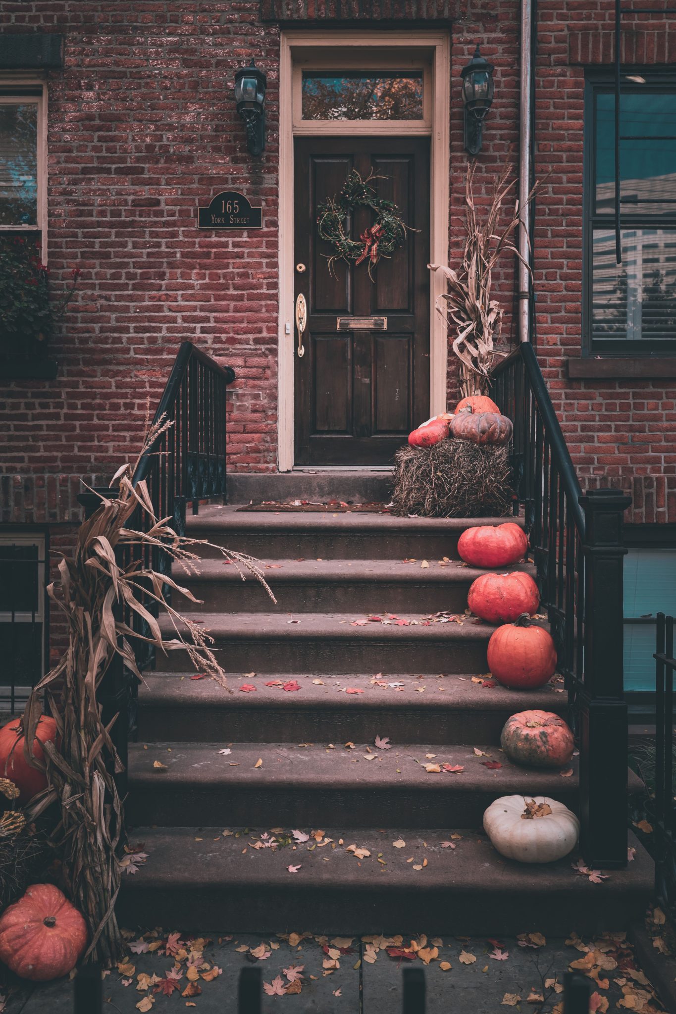 Charming front porch with pumpkins and fall decor, perfect for Halloween ambiance.