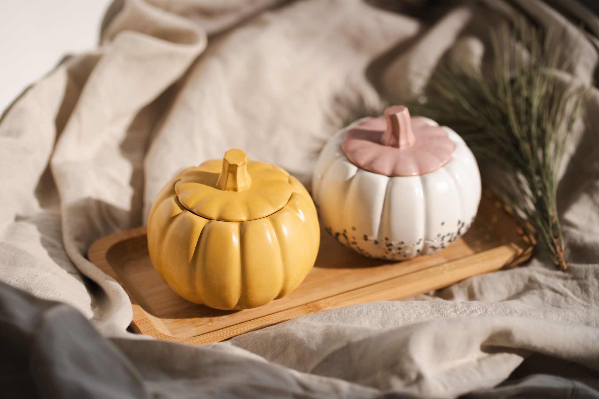Chic ceramic pumpkins on a wooden tray, perfect for cozy fall decor and autumn aesthetics.