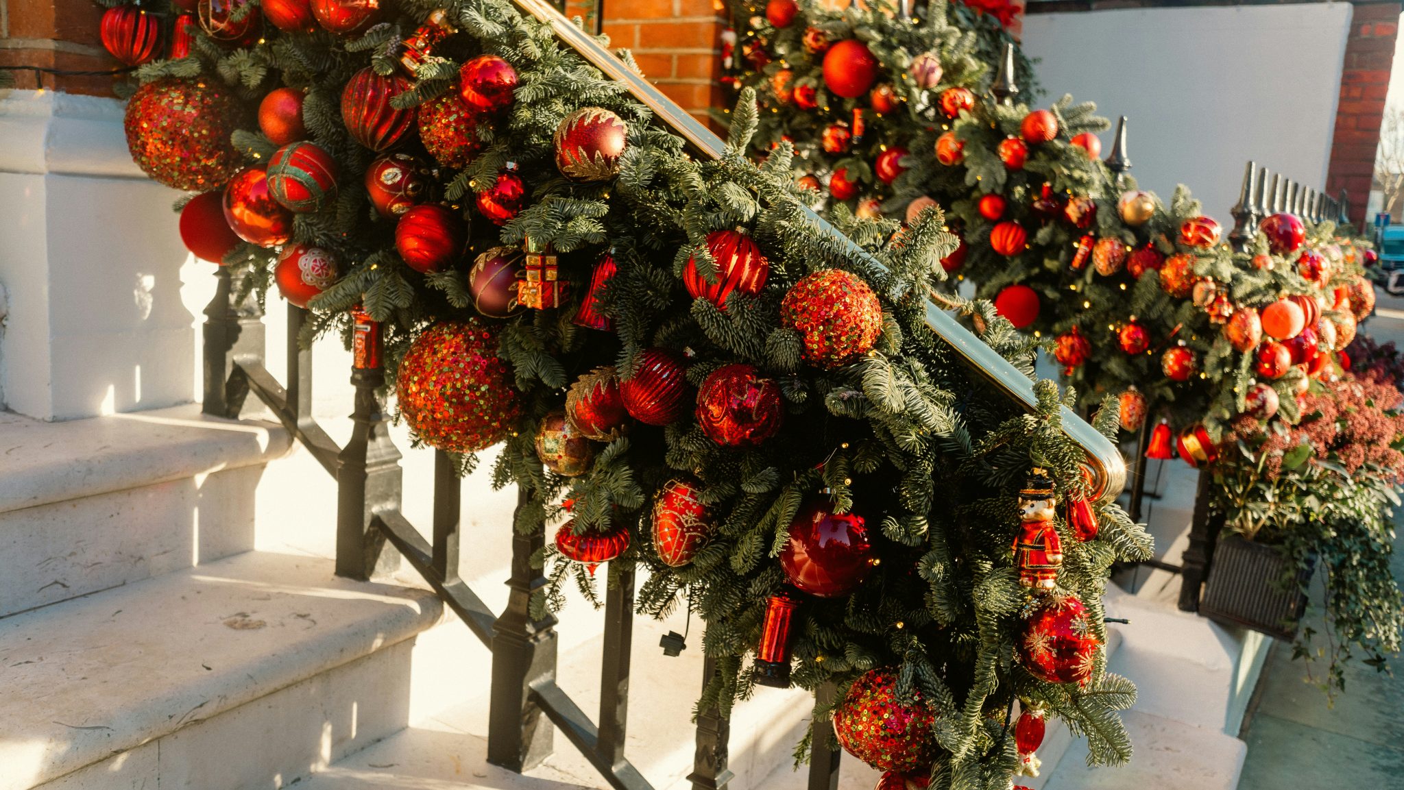 Christmas garland with red ornaments on staircase railing