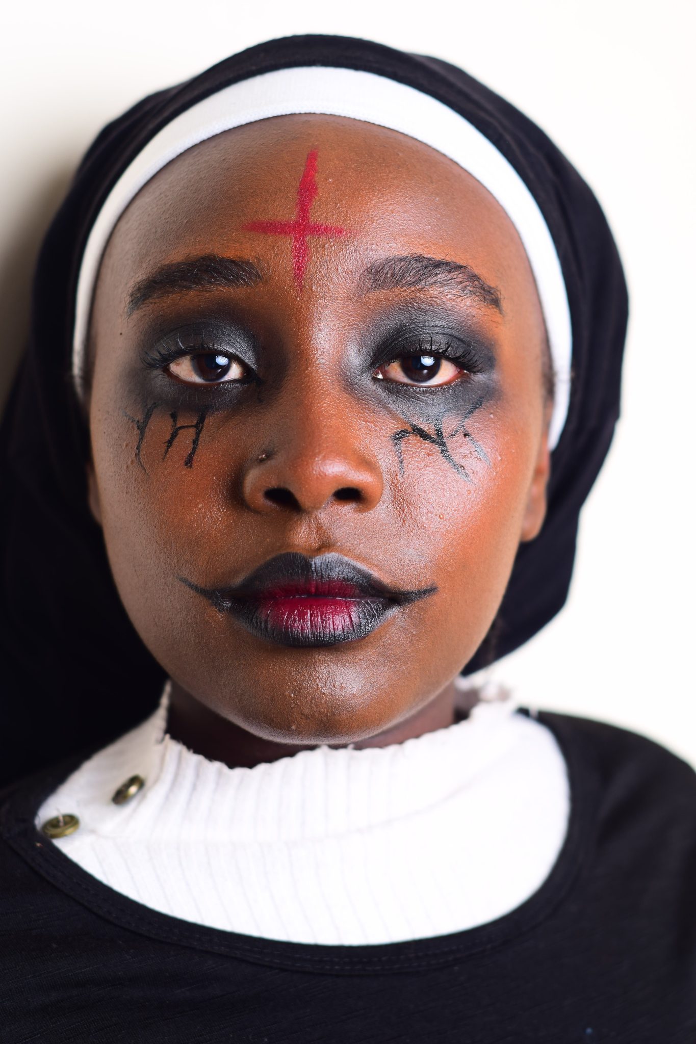 Close-up of a woman in nun costume with gothic Halloween makeup.