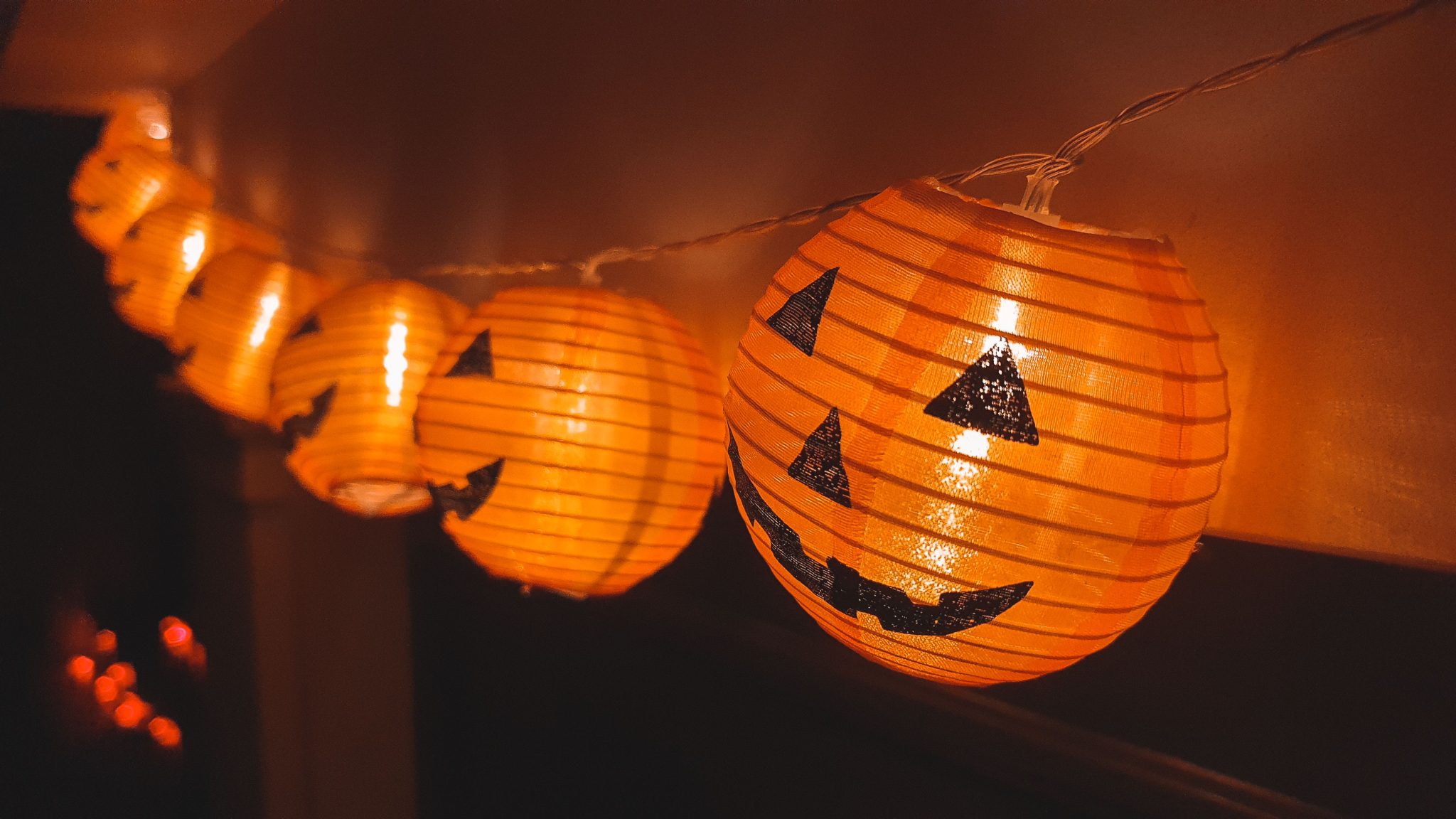 Close-up of festive Halloween pumpkin lantern string lights indoors.