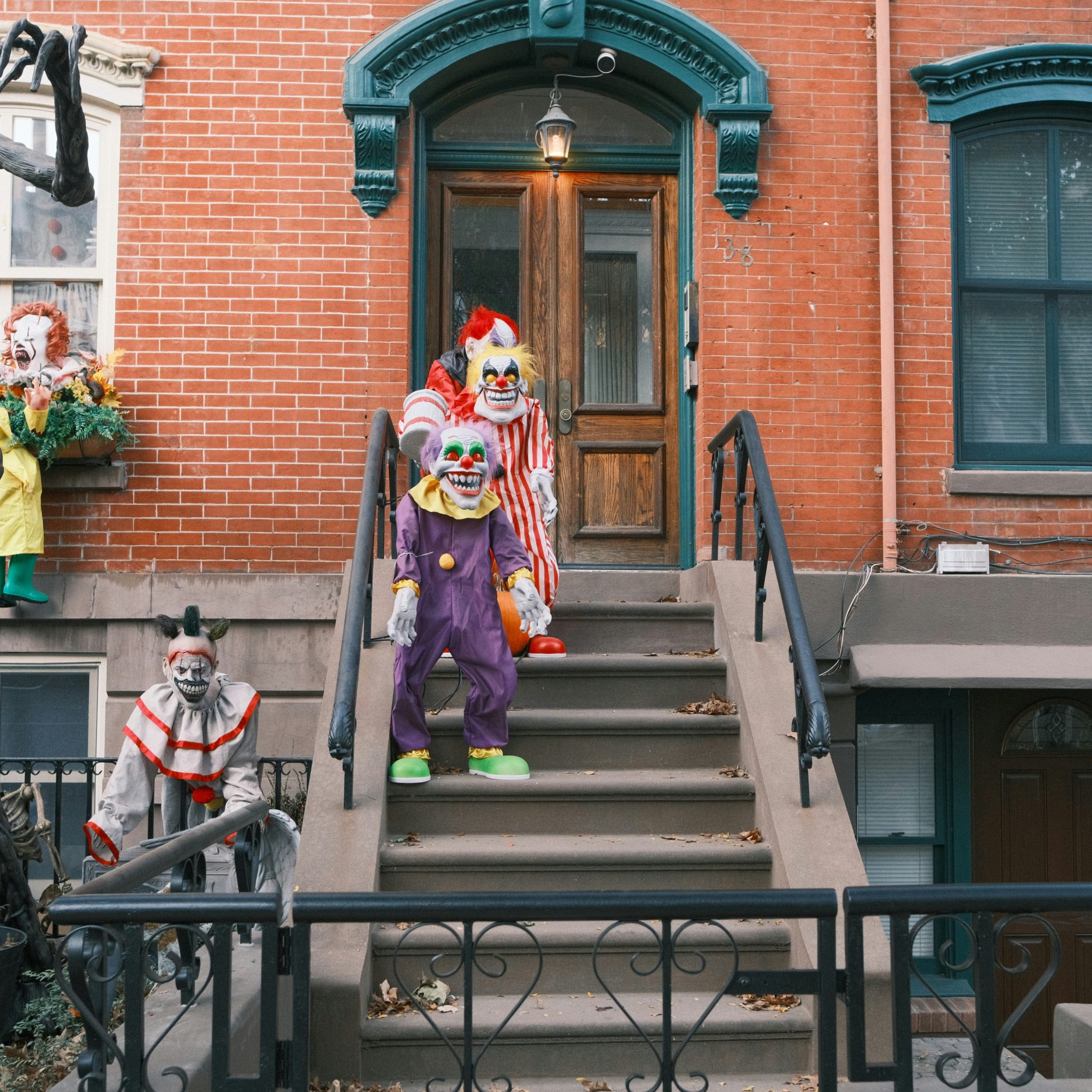 Clown figures decorate the steps of a brick building