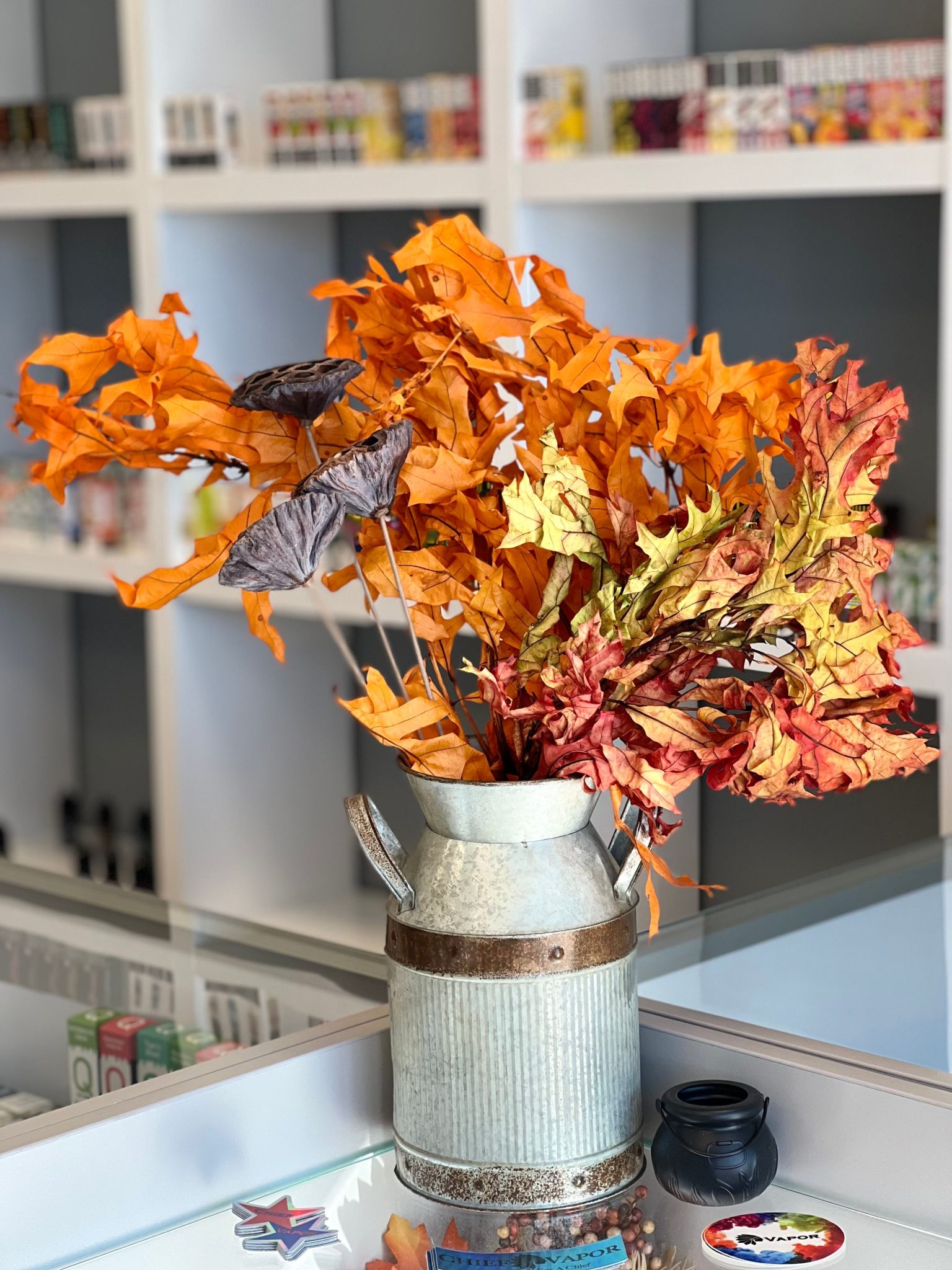 Colorful autumn leaves in a rustic metal vase creating a cozy indoor decoration.