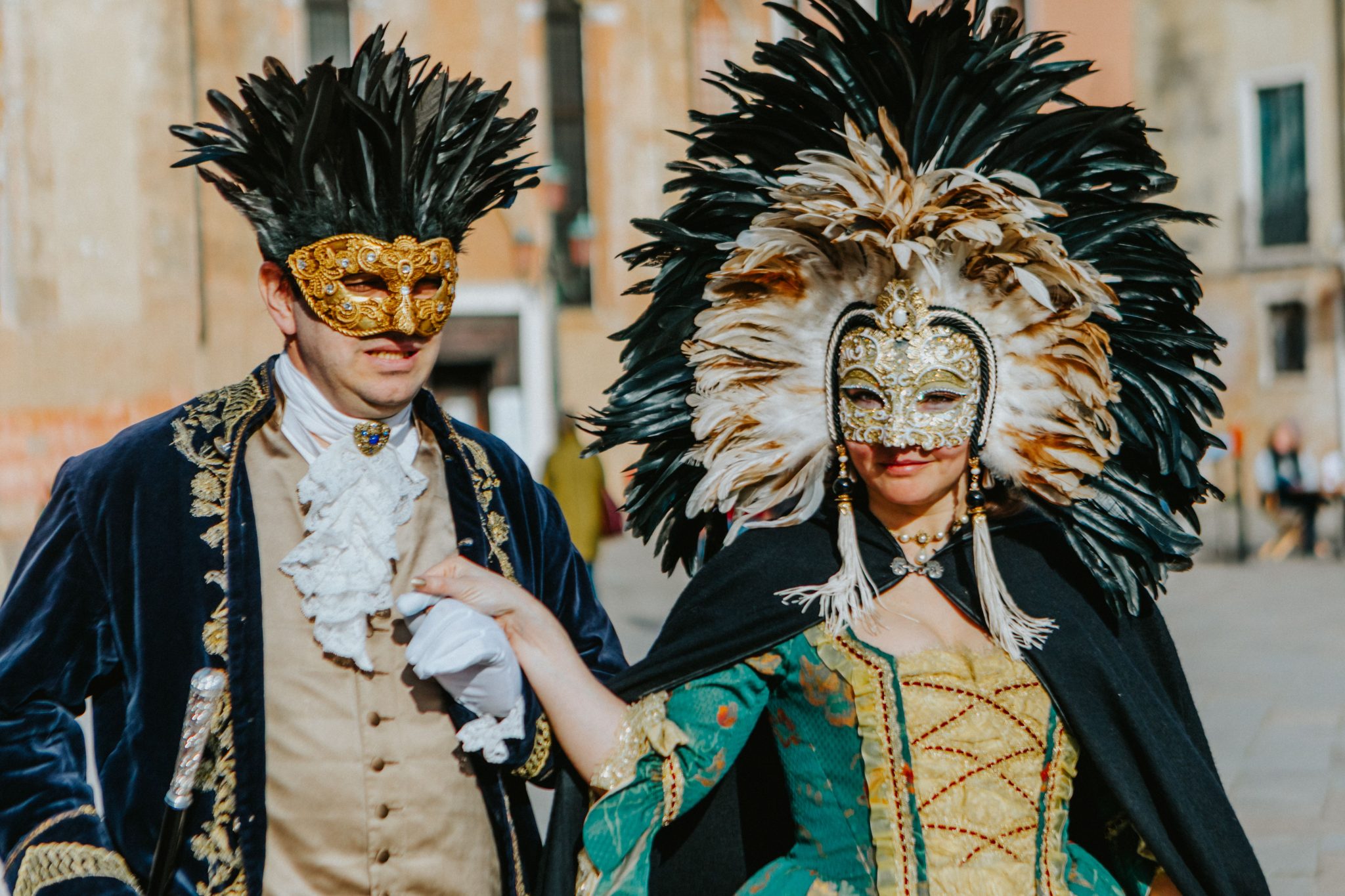 Couple in elaborate feathered masks and costumes at the Venetian Carnival.