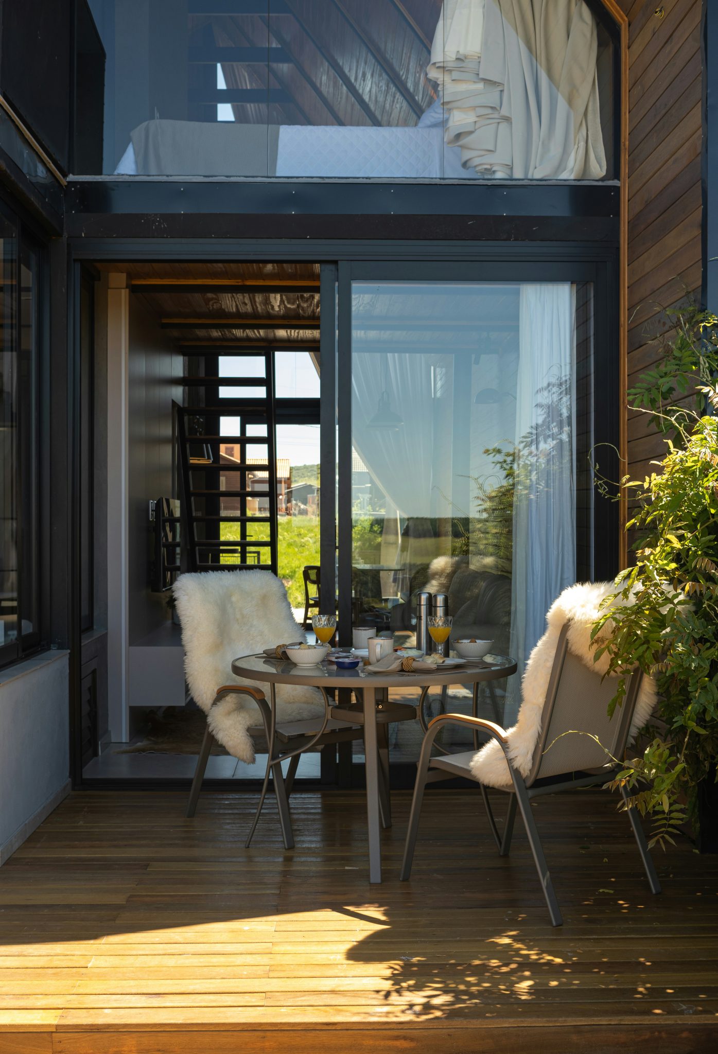 Cozy outdoor seating area with breakfast table and lush greenery.