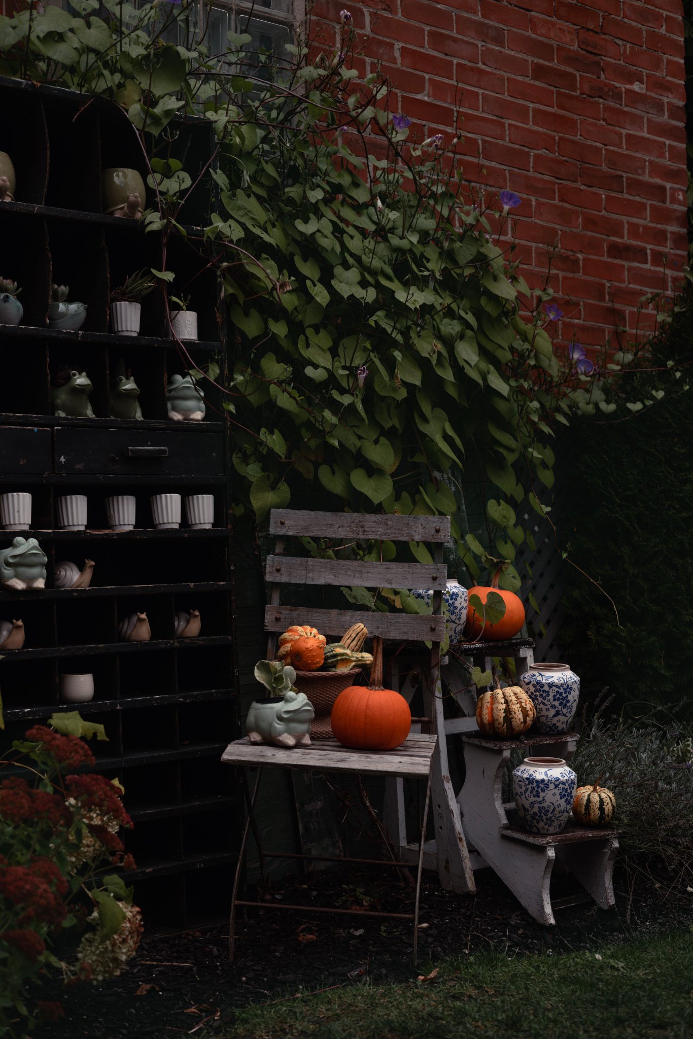 Cozy outdoor setup with pumpkins and pottery, ideal for Halloween atmosphere.