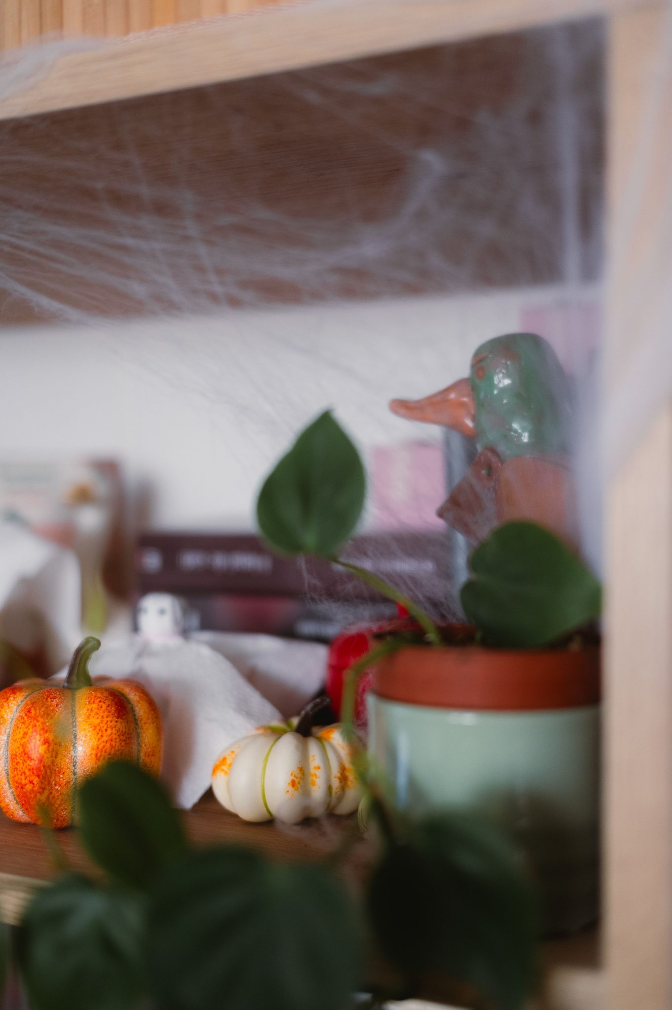 Decorative shelf with pumpkins, leaves, and Halloween ghost accents.