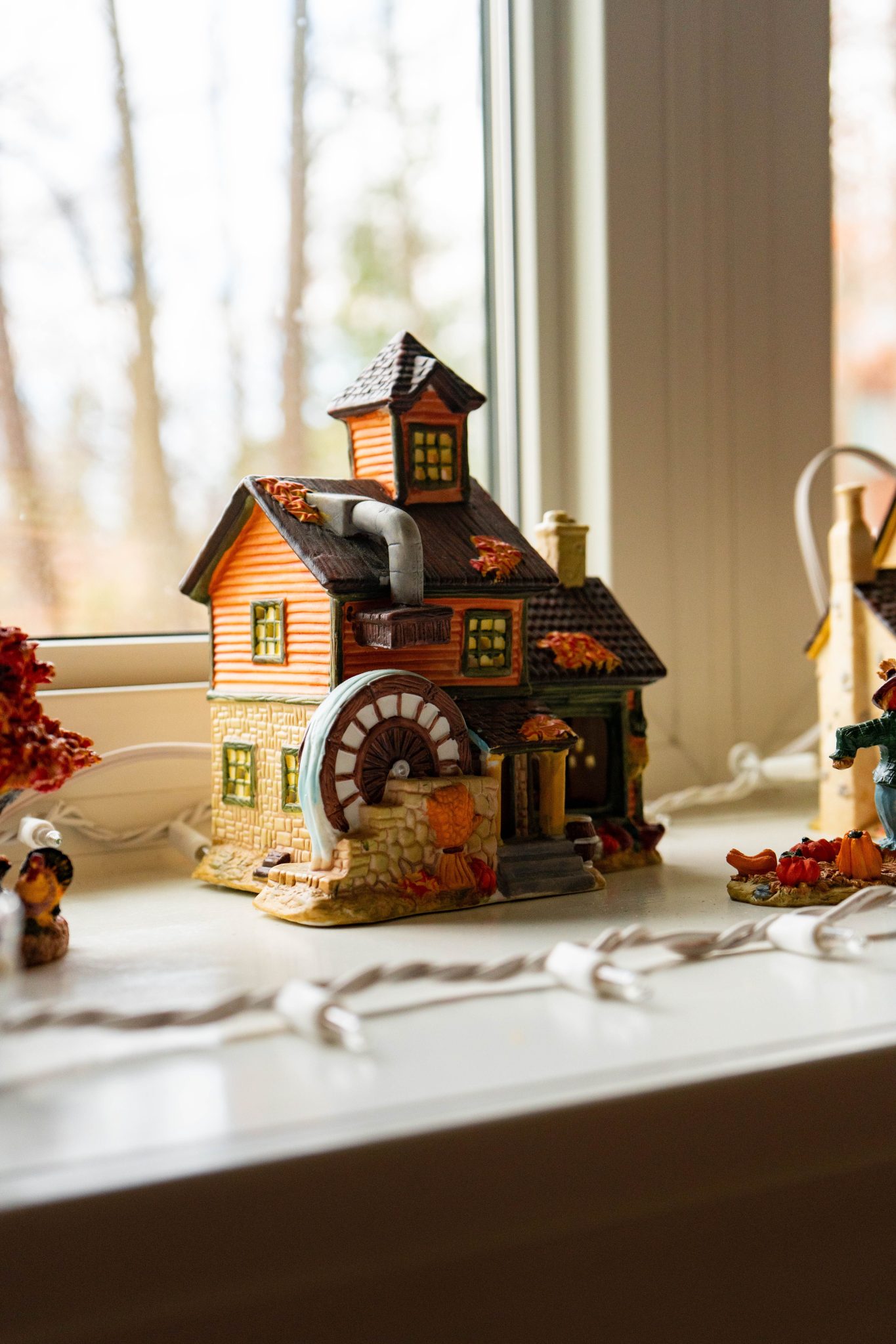 Detailed miniature village house with autumn accents, perfect for holiday displays.
