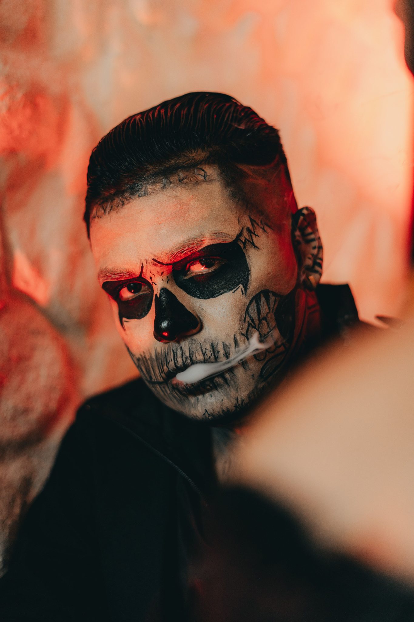 Dramatic portrait of a man with intricate skull face paint, perfect for Halloween.