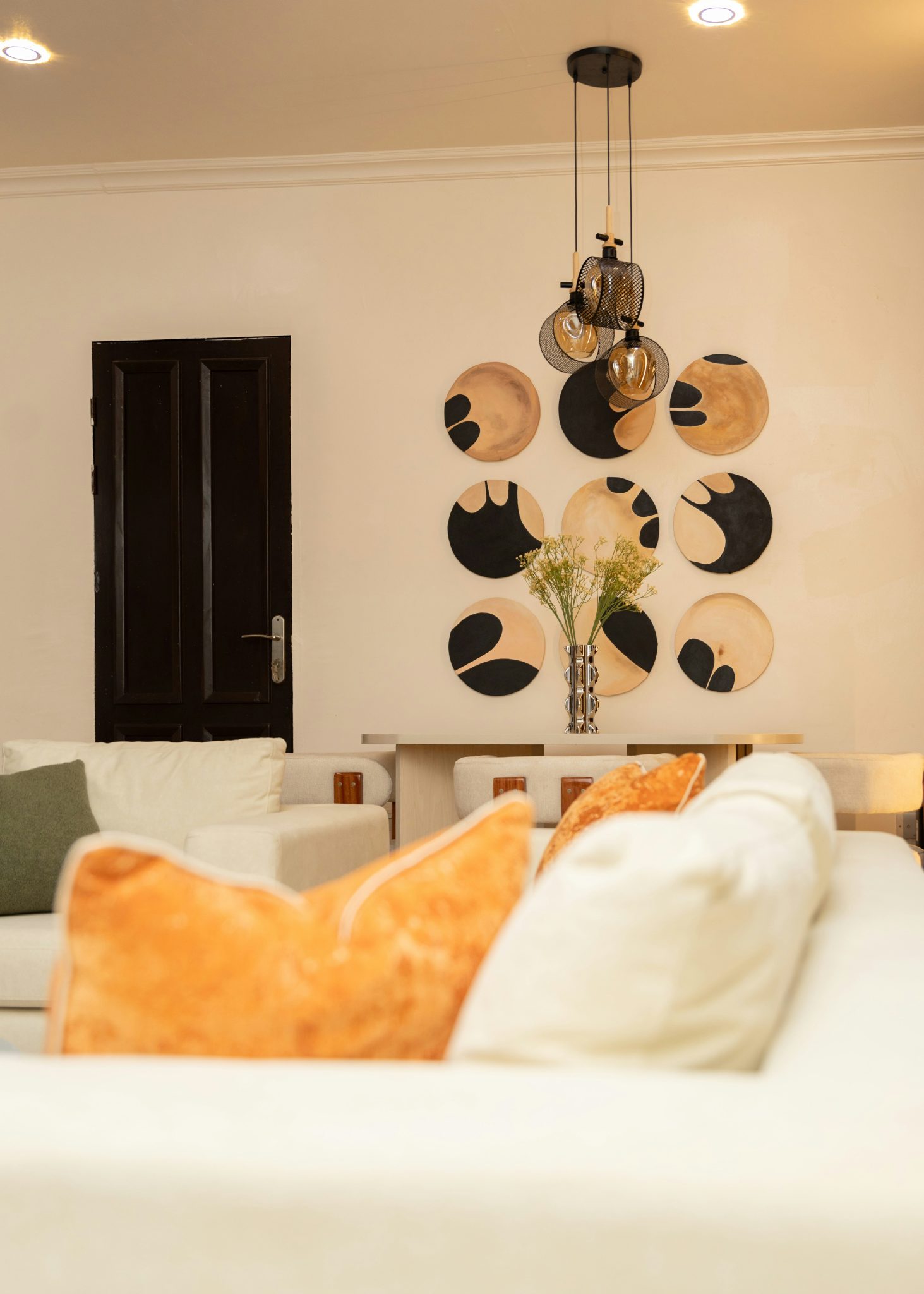Elegant living room featuring circular wall art and modern lighting.