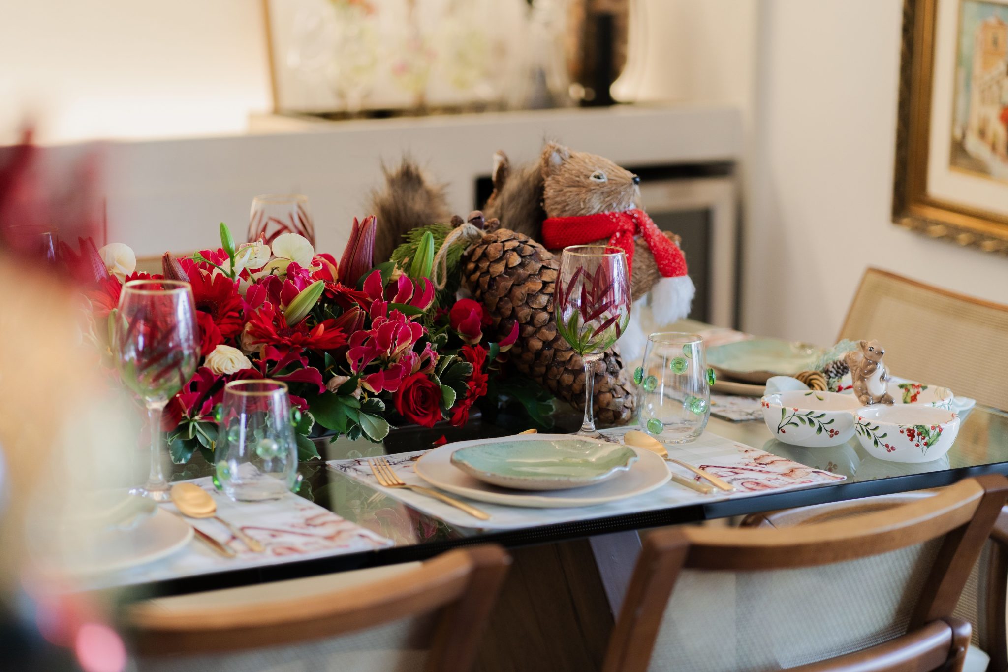 Elegant table setting with a red floral centerpiece and decorative elements.