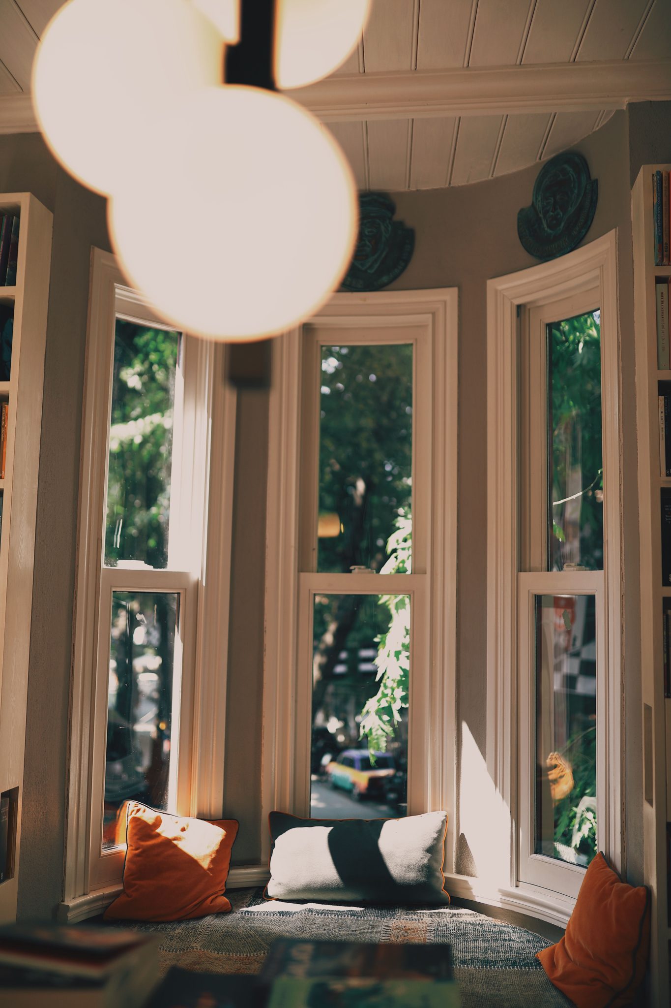 Inviting bay window seat with pillows and warm lighting, creating a peaceful reading nook.