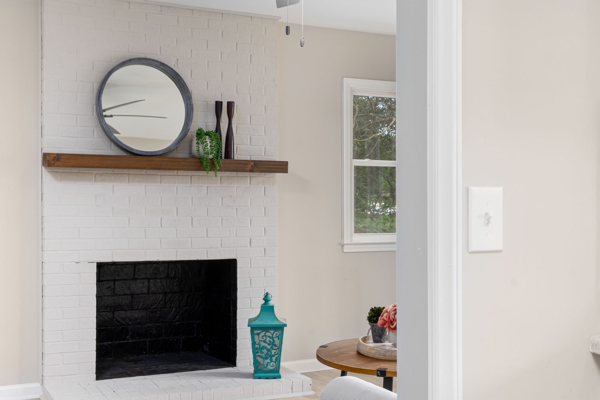 Modern living room with a stylish white brick fireplace and elegant decor elements.