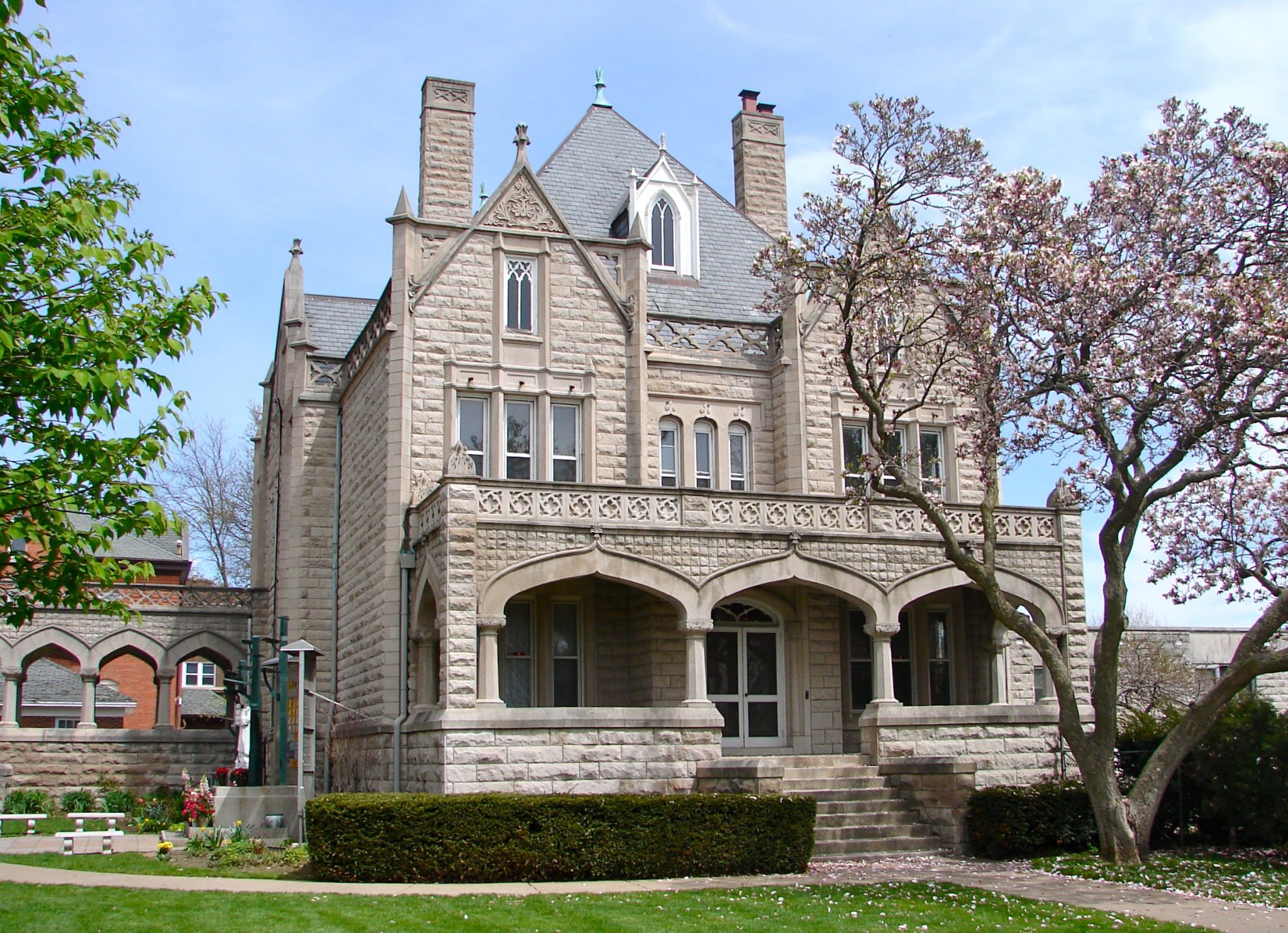 Neo-Gothic Facade: Sandstone Mansion with Ornate Parapet and Pointed Arches