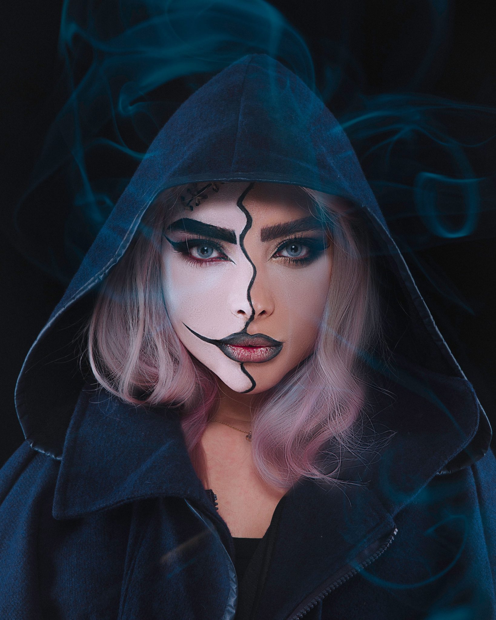 Portrait of a woman with creative makeup and hood. Mysterious and artistic vibe.