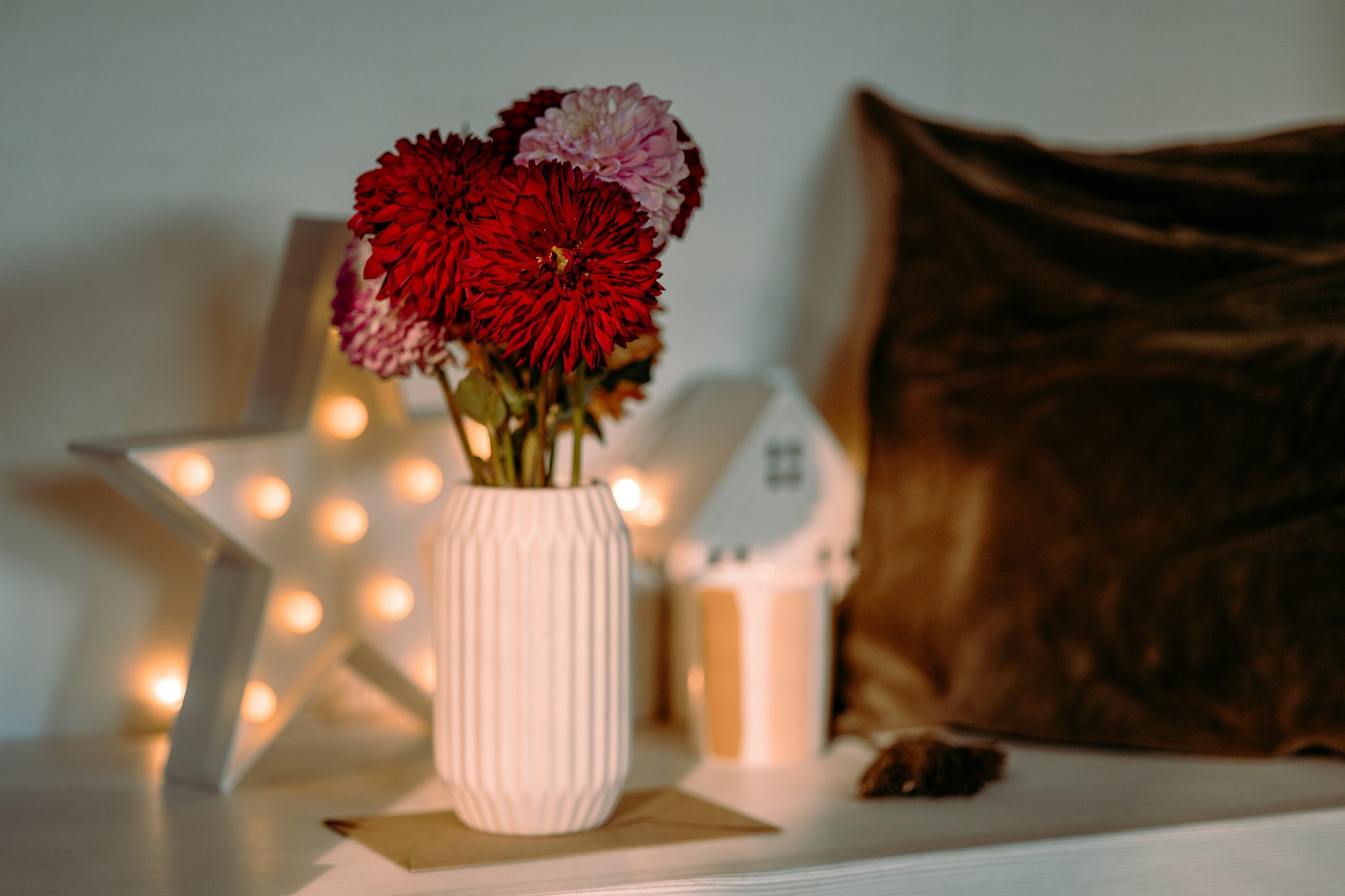 Still life with red dahlias, candles, cozy home decor
