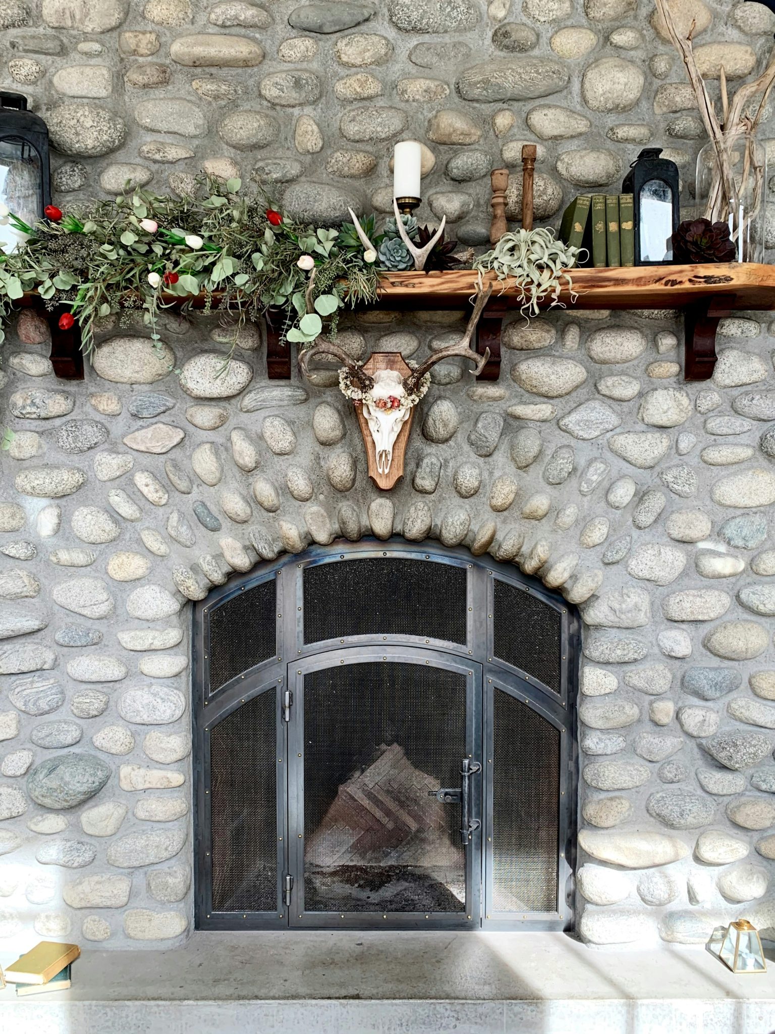 Stone fireplace with floral arrangement on the mantel