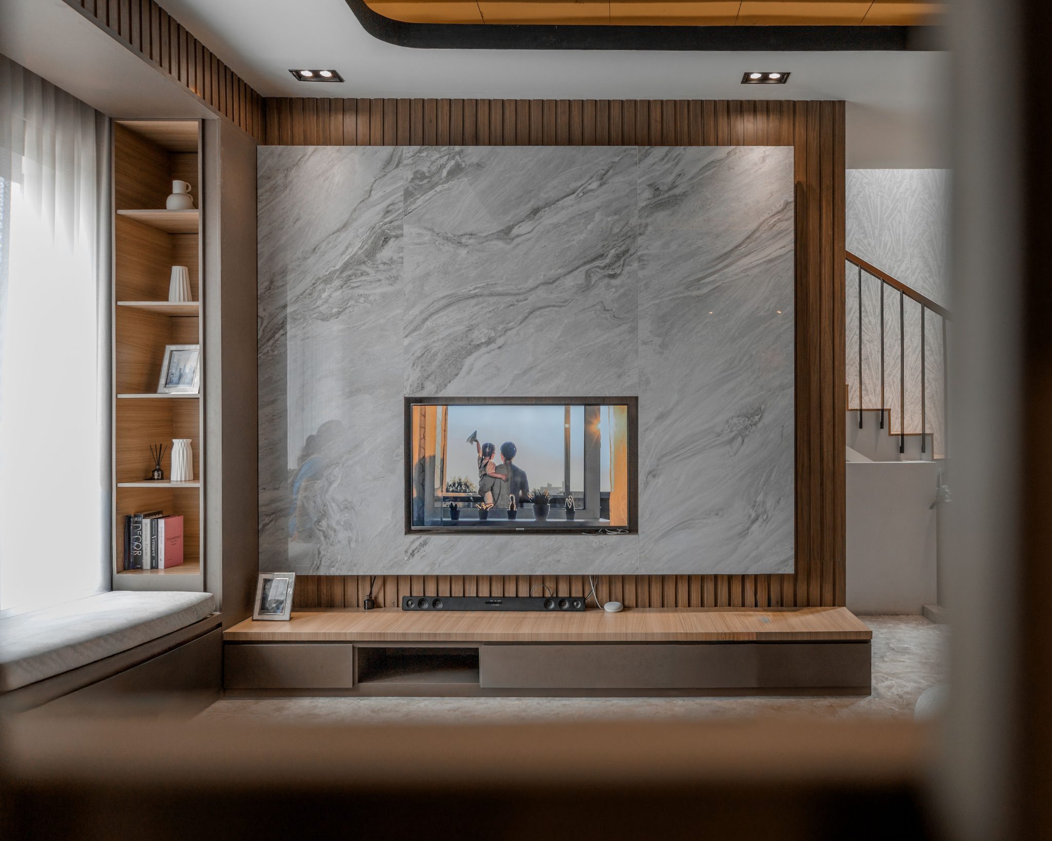Stylish living room with stone fireplace and TV, showcasing contemporary decor and cozy atmosphere.