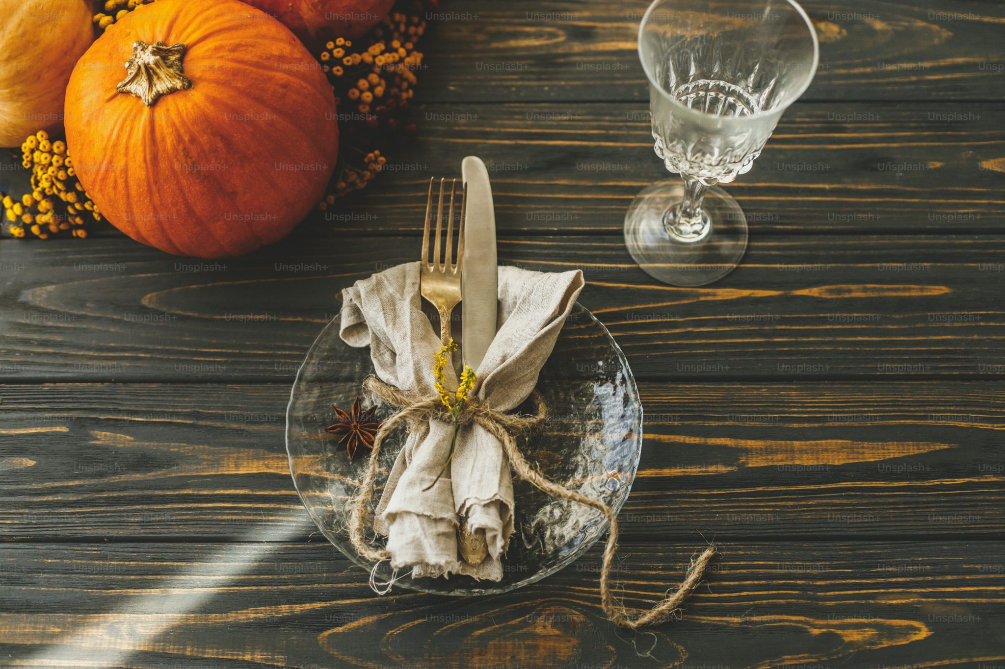 Thanksgiving dinner table setting. Stylish plate with cutlery, linen napkin and pumpkin with autumnal flowers on rustic table. Autumn wedding catering, eco friendly arrangement photo – Autumn Image 