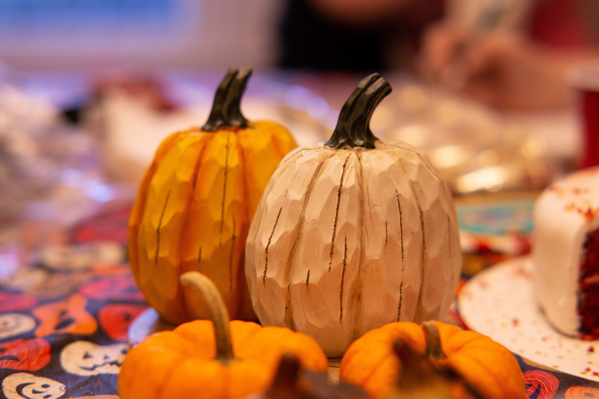 Vibrant handcrafted pumpkins on a festive table set for a warm, cozy autumn celebration.