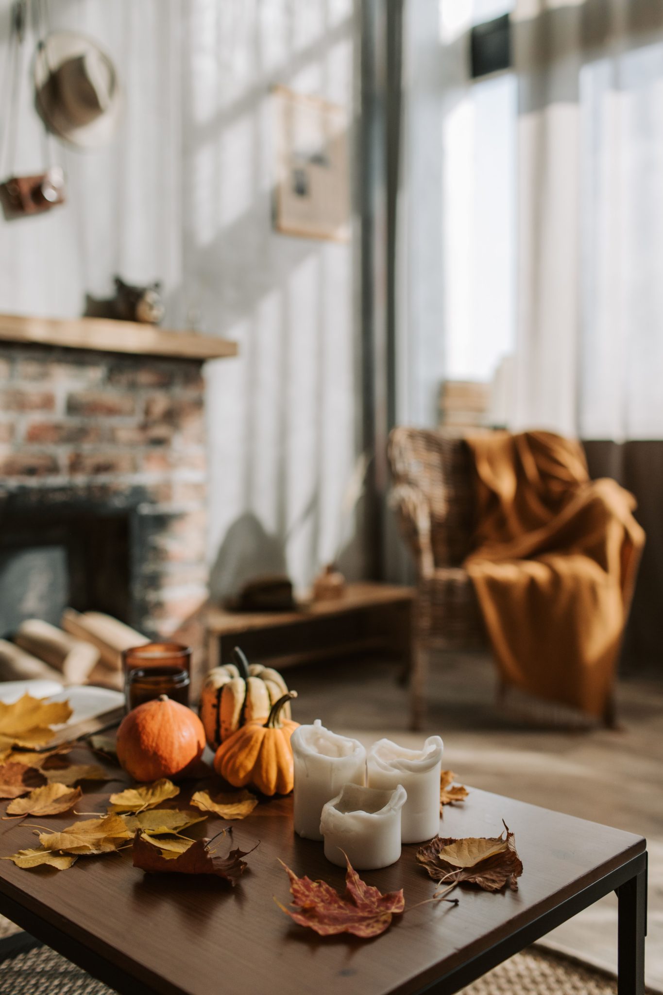 Warm and inviting living room with pumpkins and candles on a wooden table, perfect for cozy autumn nights.