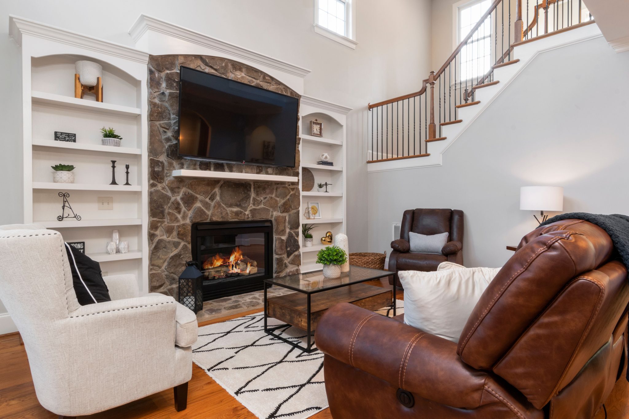 Warm and inviting living room with stone fireplace and modern furniture.