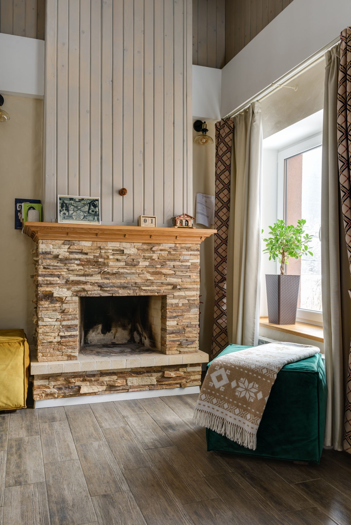 Warm and inviting living room with stone fireplace, wood accents, and natural light.