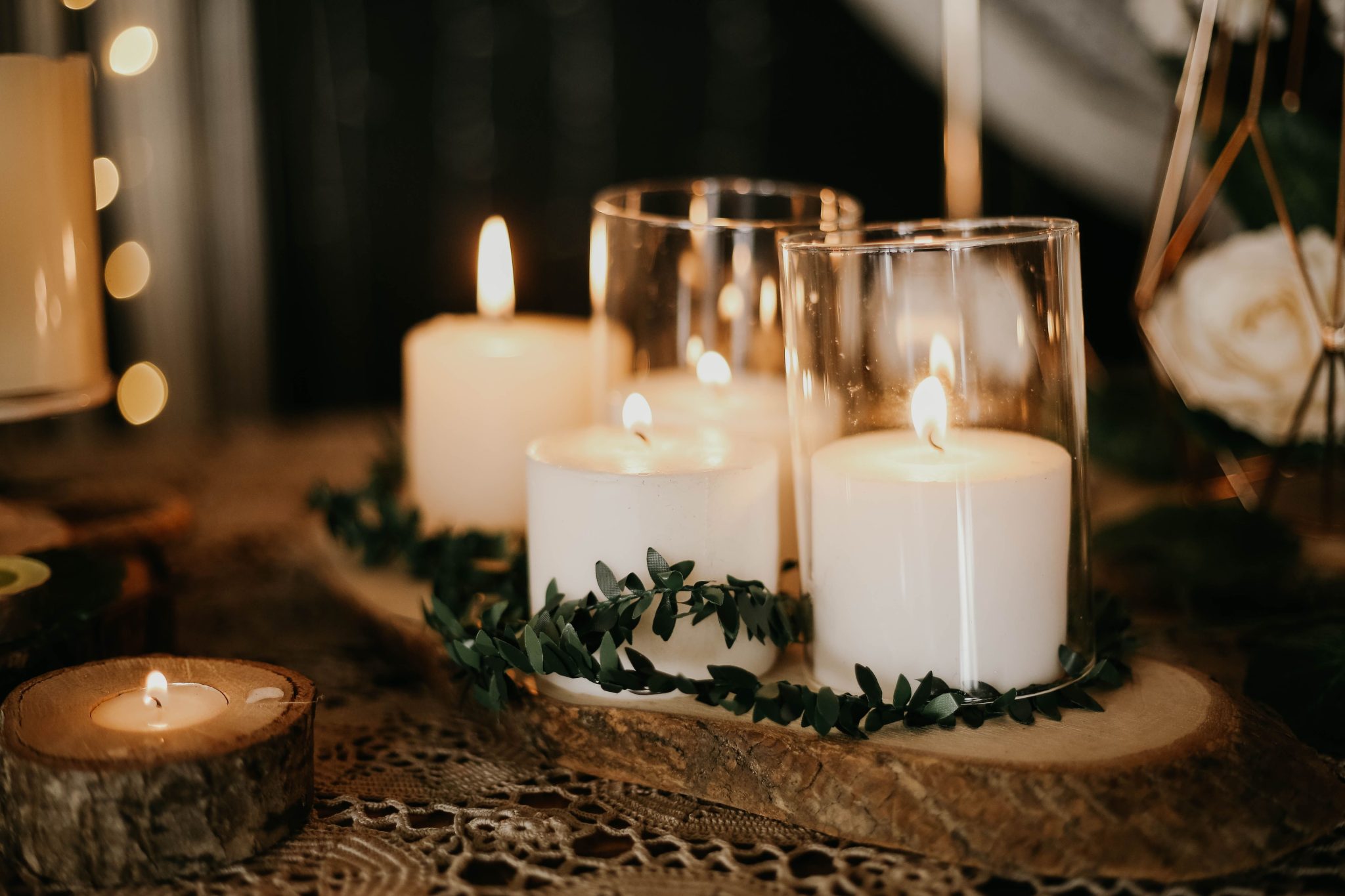 Warm candlelit scene featuring grouped candles with greenery, perfect for relaxation.