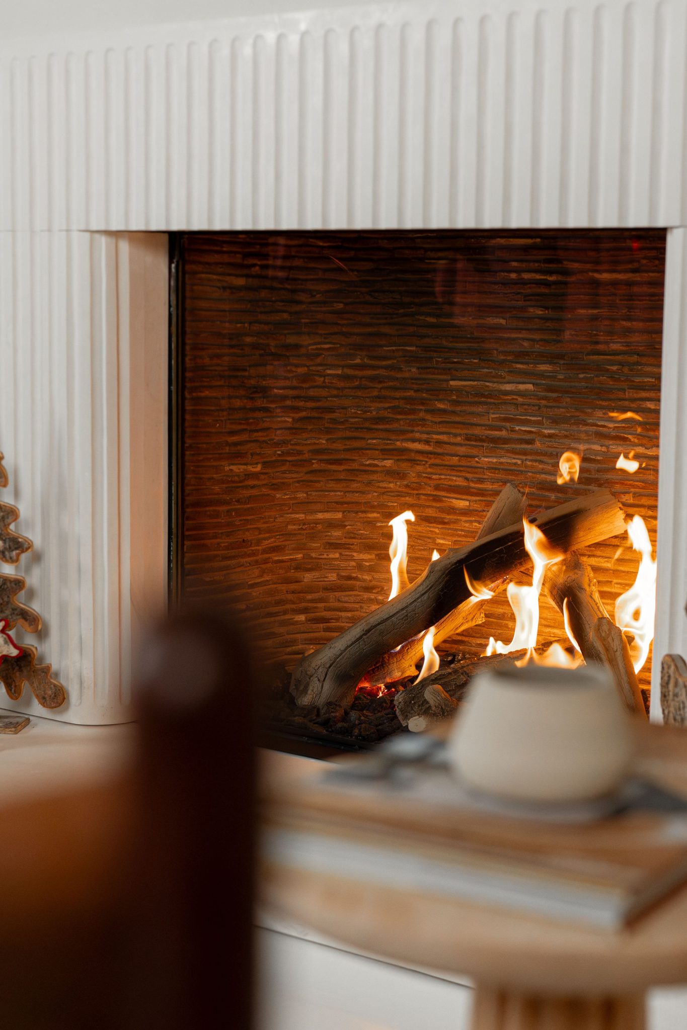Warm indoor setting with an inviting, lit fireplace ideal for cozy winter evenings.