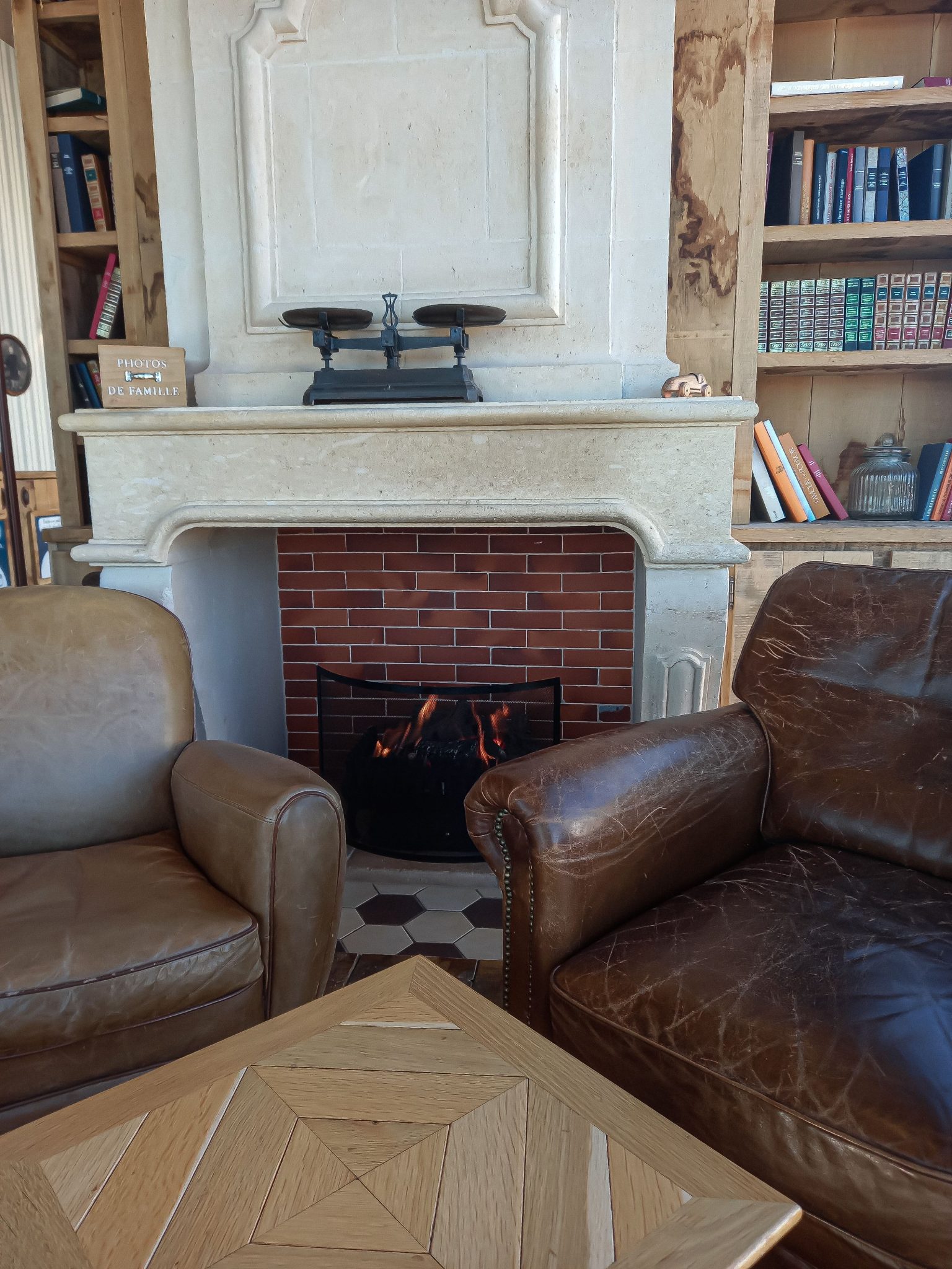 Warm living room featuring a stone fireplace and leather armchairs.