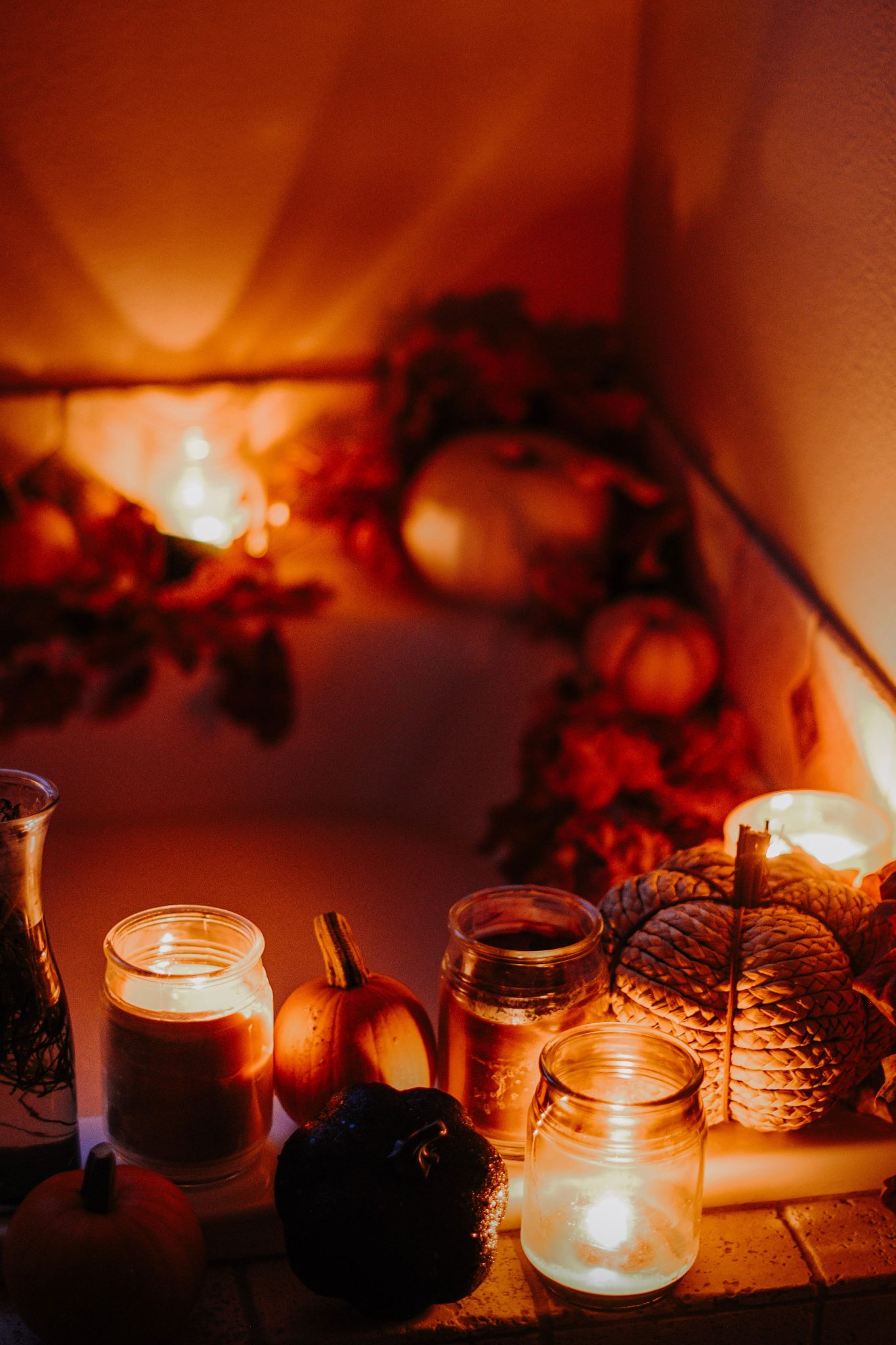 Warmly lit bathtub with candles and pumpkins, perfect for a cozy autumn evening.