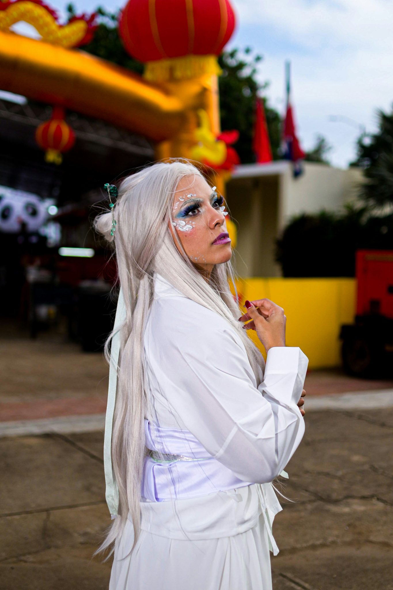 Woman in white with elaborate makeup and white hair