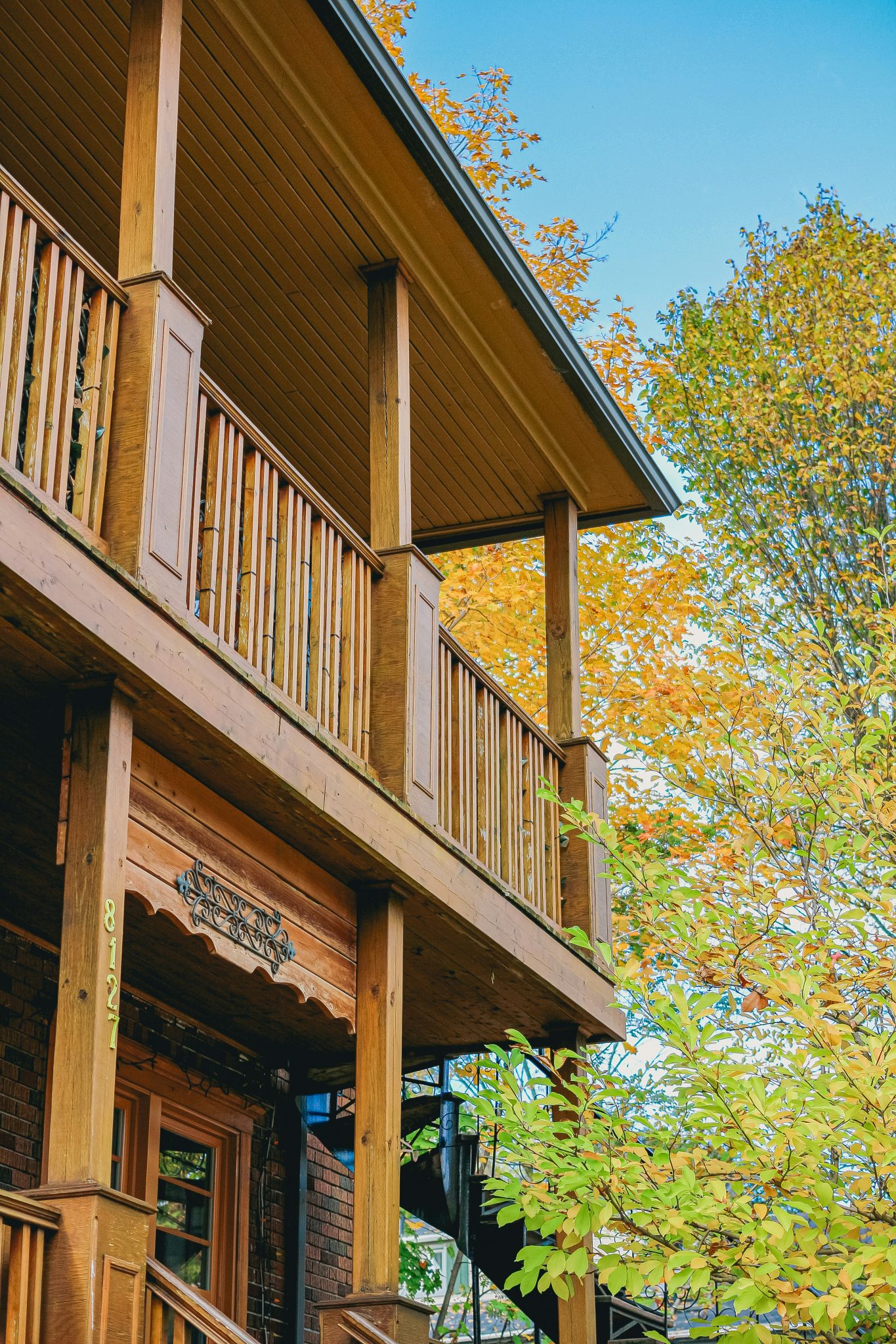 Wooden house with autumn foliage and blue sky