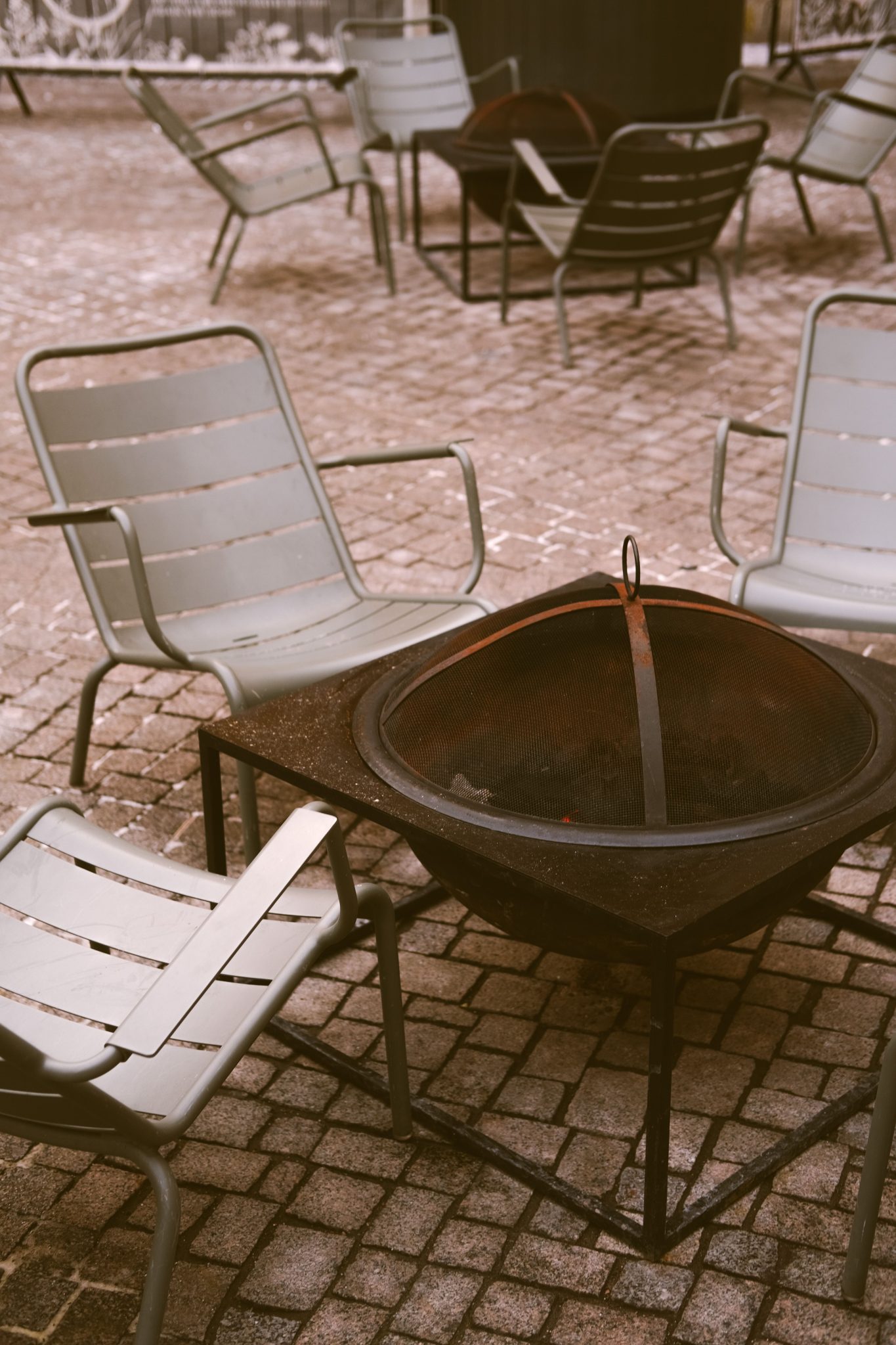 A charming outdoor patio scene featuring chairs and a central fire pit perfect for cozy gatherings.