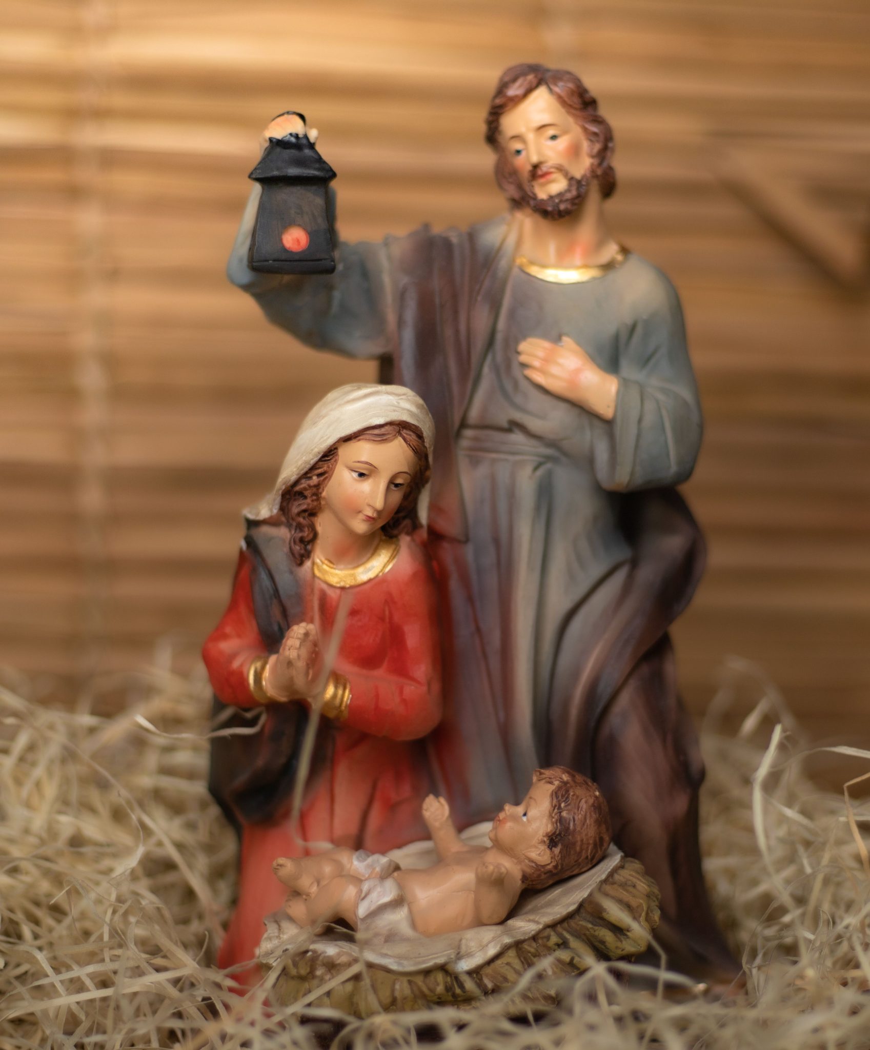 A detailed, colorful nativity scene depicting baby Jesus with Mary and Joseph in a stable setting.
