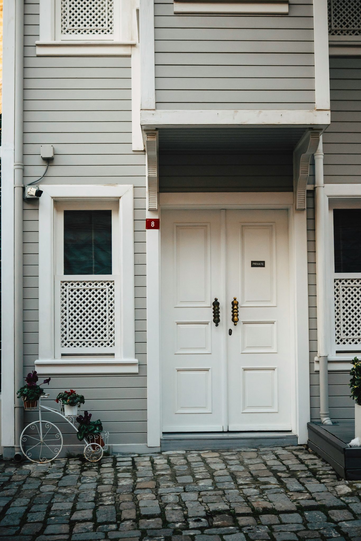 A gray house with white door and window