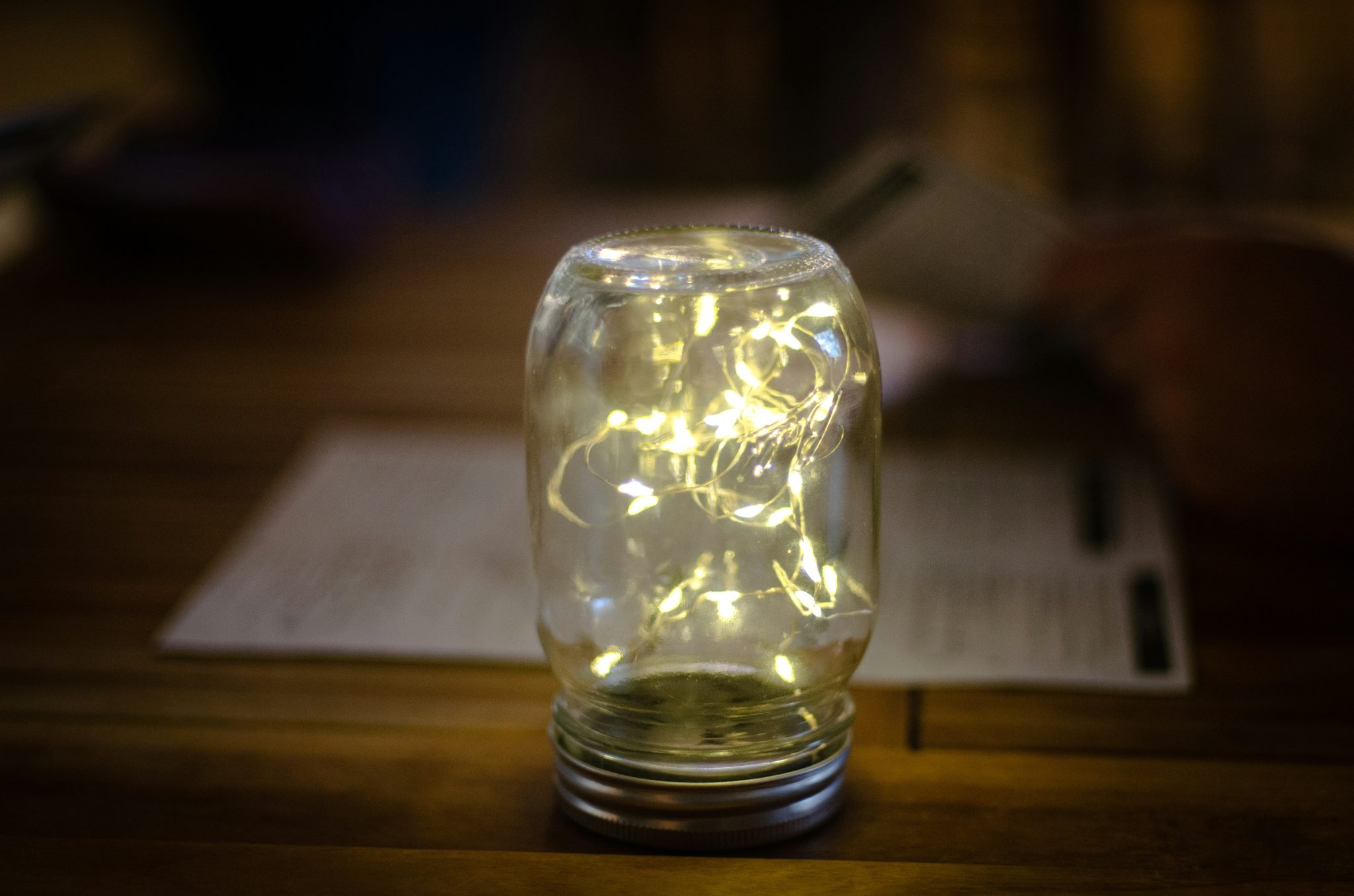 a mason jar filled with fairy lights on a table