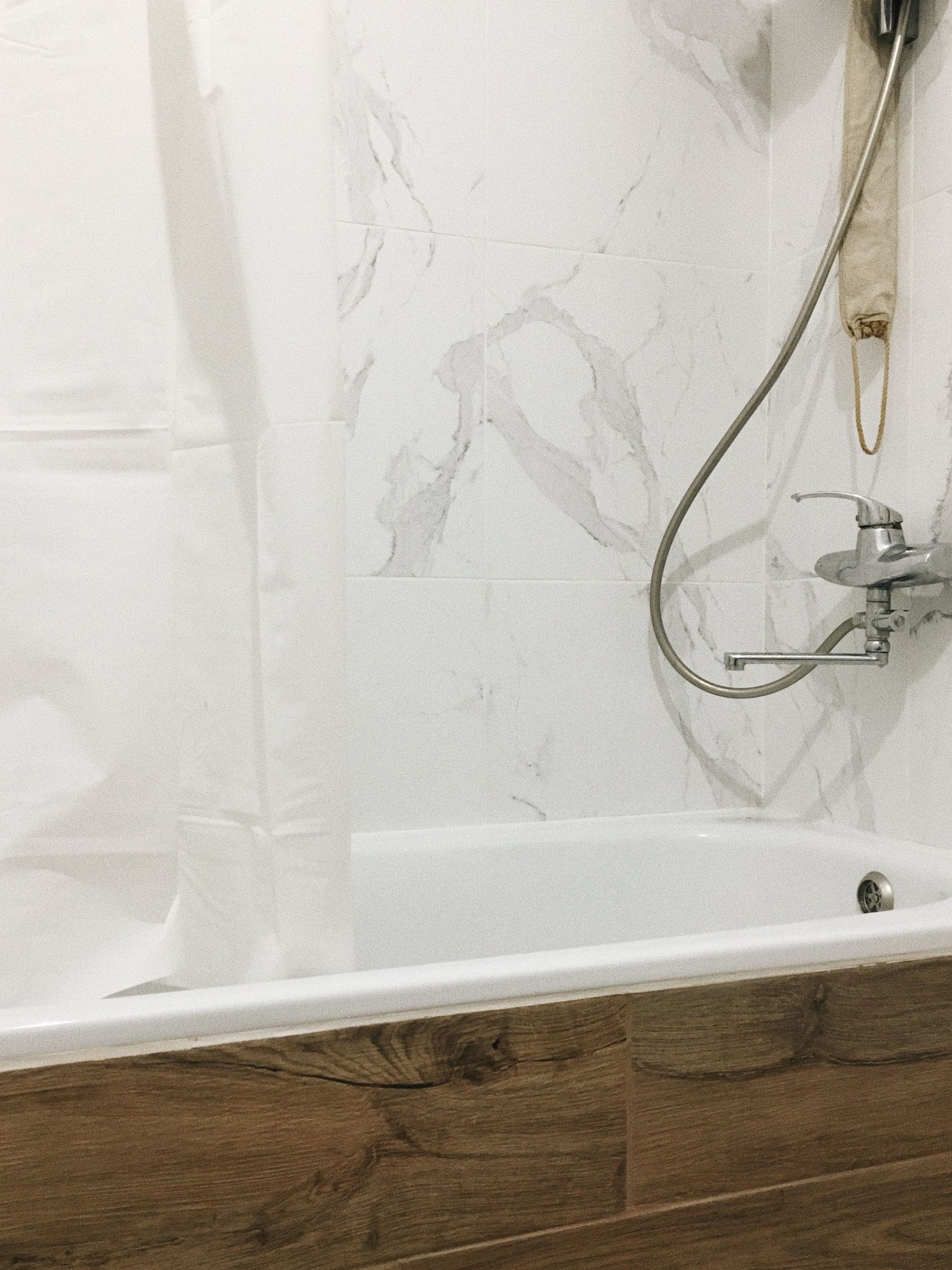 A modern bathroom with marble tiles, bathtub, and minimalist fixtures, perfect for home decor inspirations.