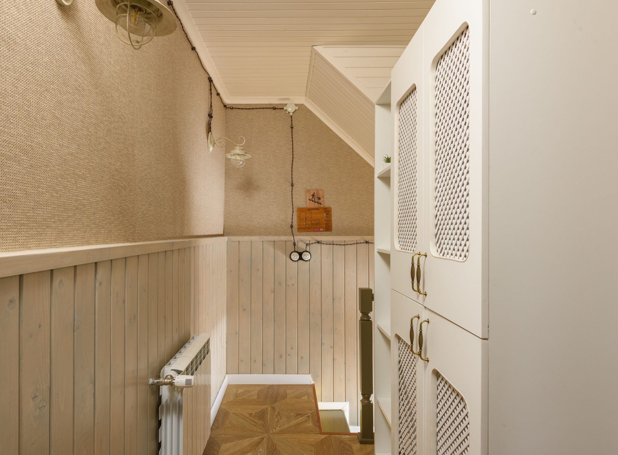 A narrow corridor featuring wooden paneling and cabinets, providing a warm and rustic ambience.